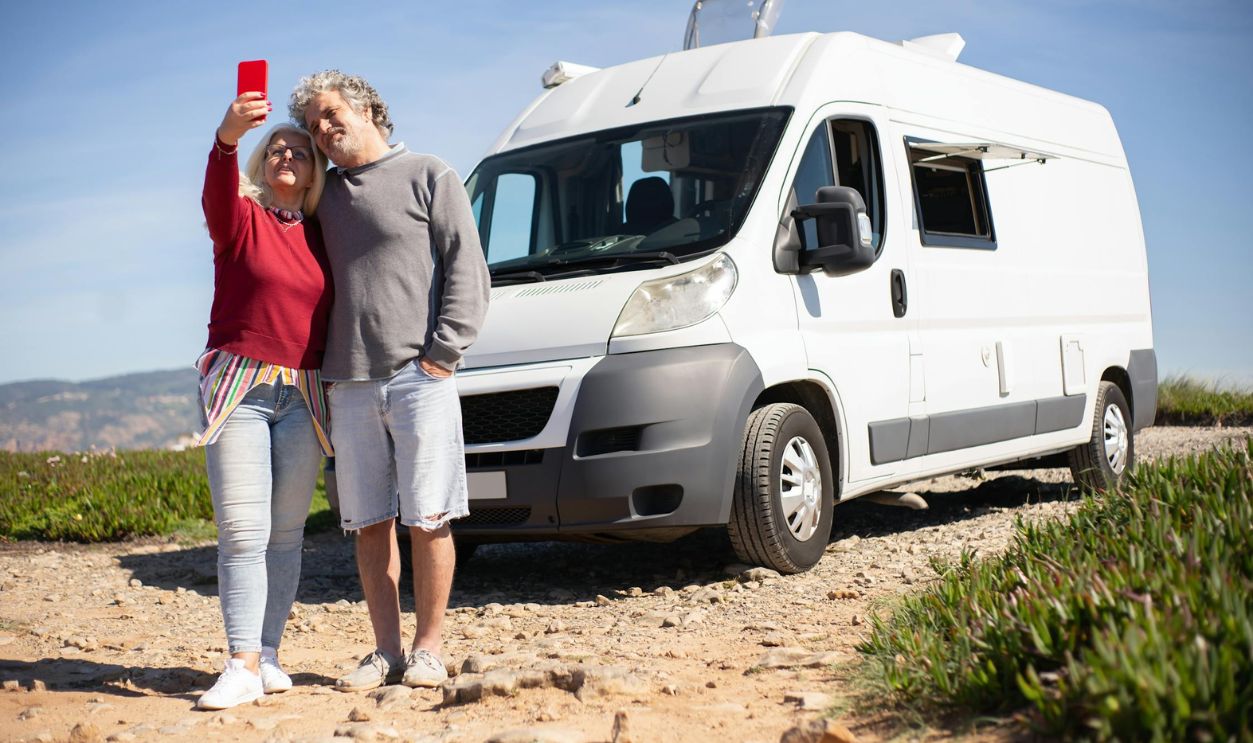 An Elderly Couple Taking a Selfie beside Their Recreational Vehicle