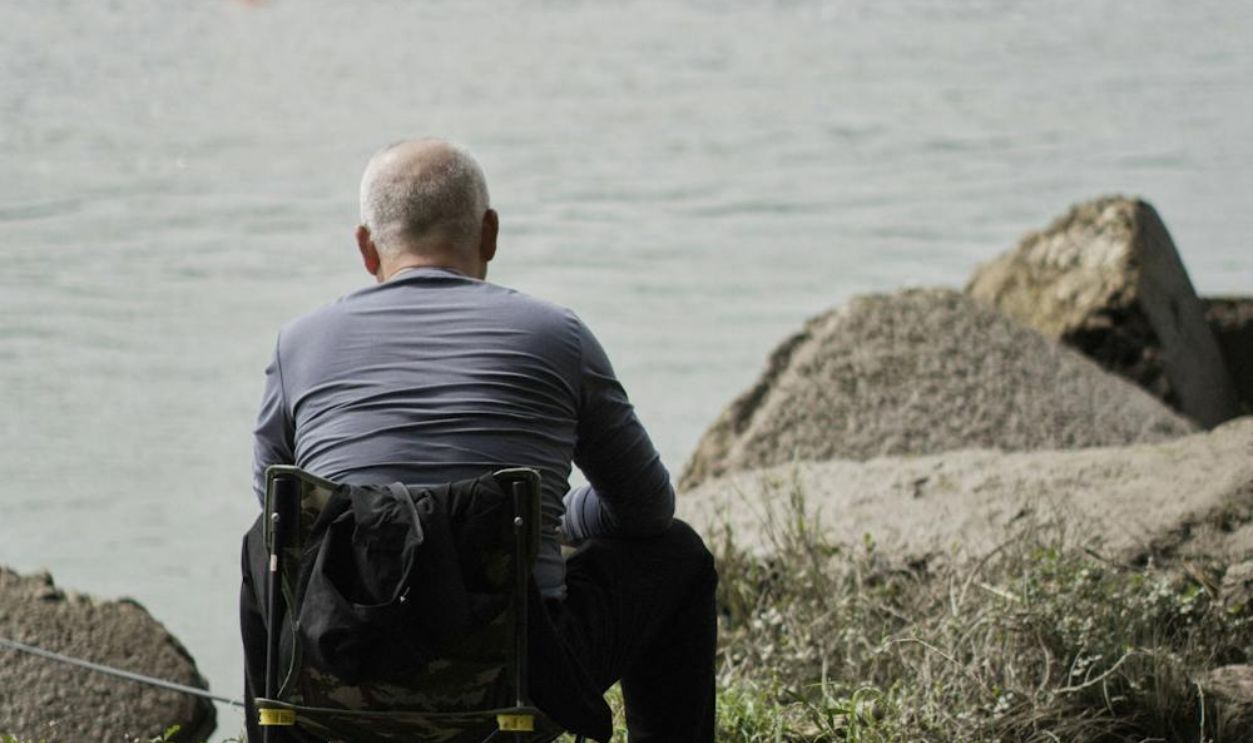 Elderly Man Sitting by River