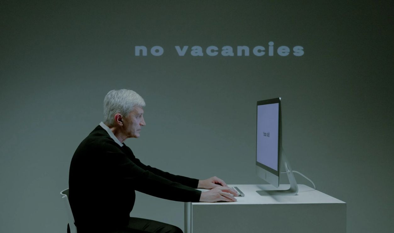 An Elderly Man with a Serious Face while using a Computer