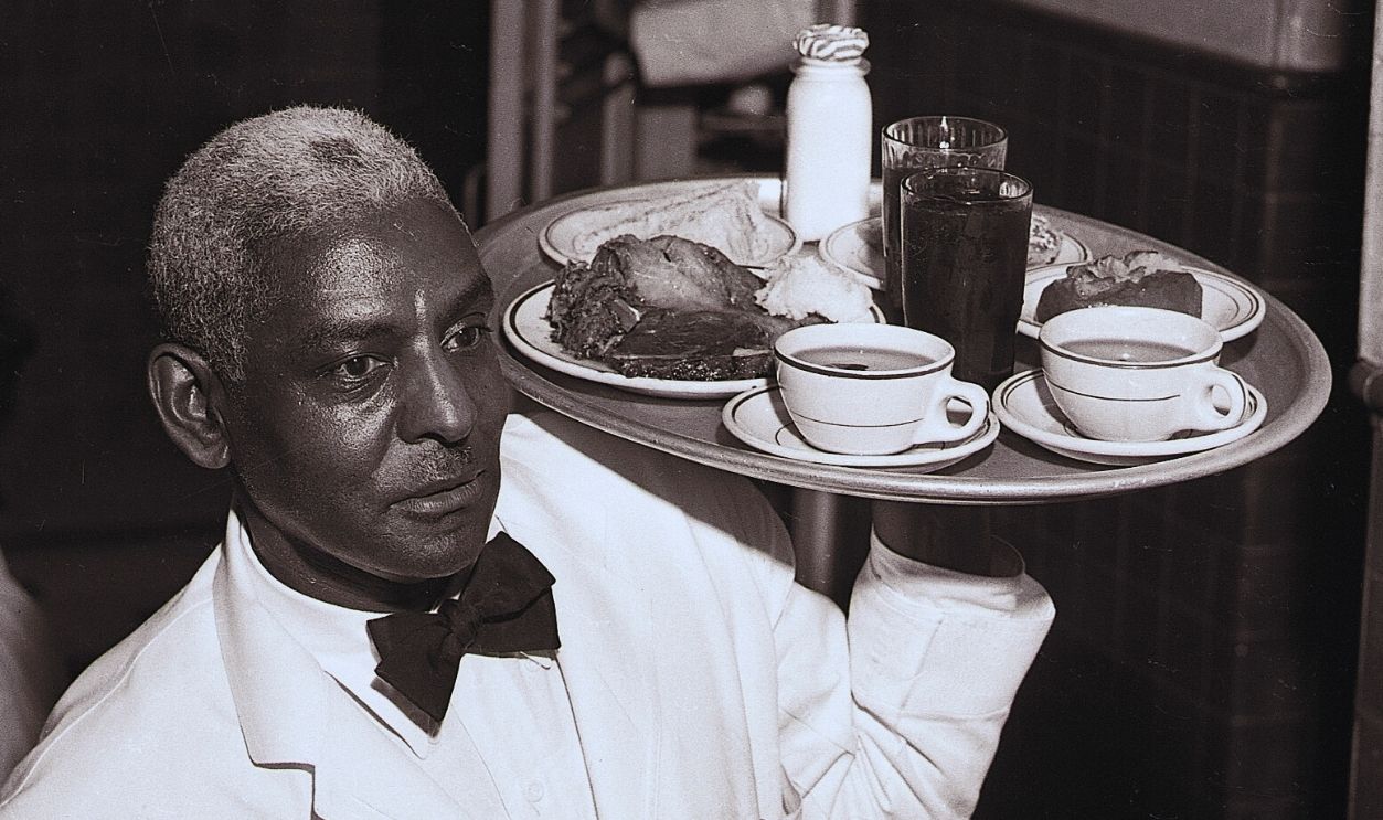 Gettyimages - 515983148, Veteran Waiter Serving in the Capitol (Original Caption) 9/24/1954-Washington, DC- Waiter Richard Lomax, employed at the House of Representatives, located in the House wing of the Capital. He has been serving the Republican round table since 1928. He is shown carrying a large tray.