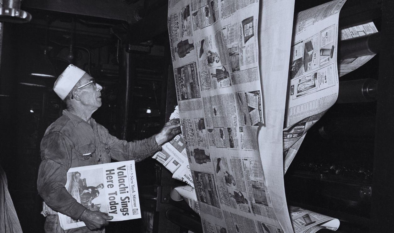 Gettyimages - 515512266, Pressman Holding Newspaper (Original Caption) Last Run. New York: An unidentified Mirror pressman holds a copy of the New York Mirror as the last edition rolls of the presses. Employees were told at 6:30 P.M. EDT that the paper was finished publishing effective tonight's edition. The Hearst publication was bought out by the New York Daily News its chief competitor.
