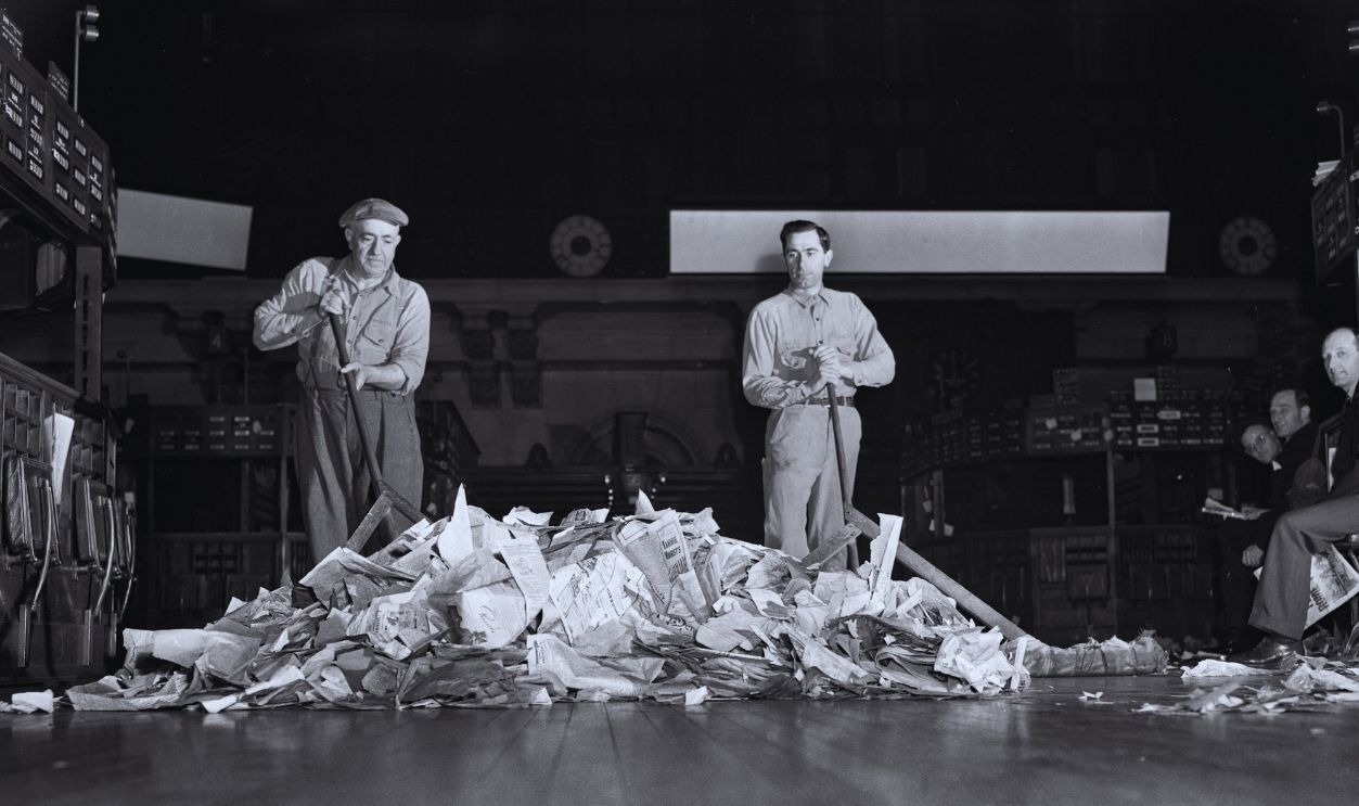 Gettyimages - 1315468844, Working on Wall Street At the end of the trading day, the floor of the New York Stock Exchange is practically ankle deep in scraps of paper. Some of these scraps carry computations that might have made or lost small fortunes. The paper is carefully swept up and salvaged at the rate of 40,000 pounds a month.