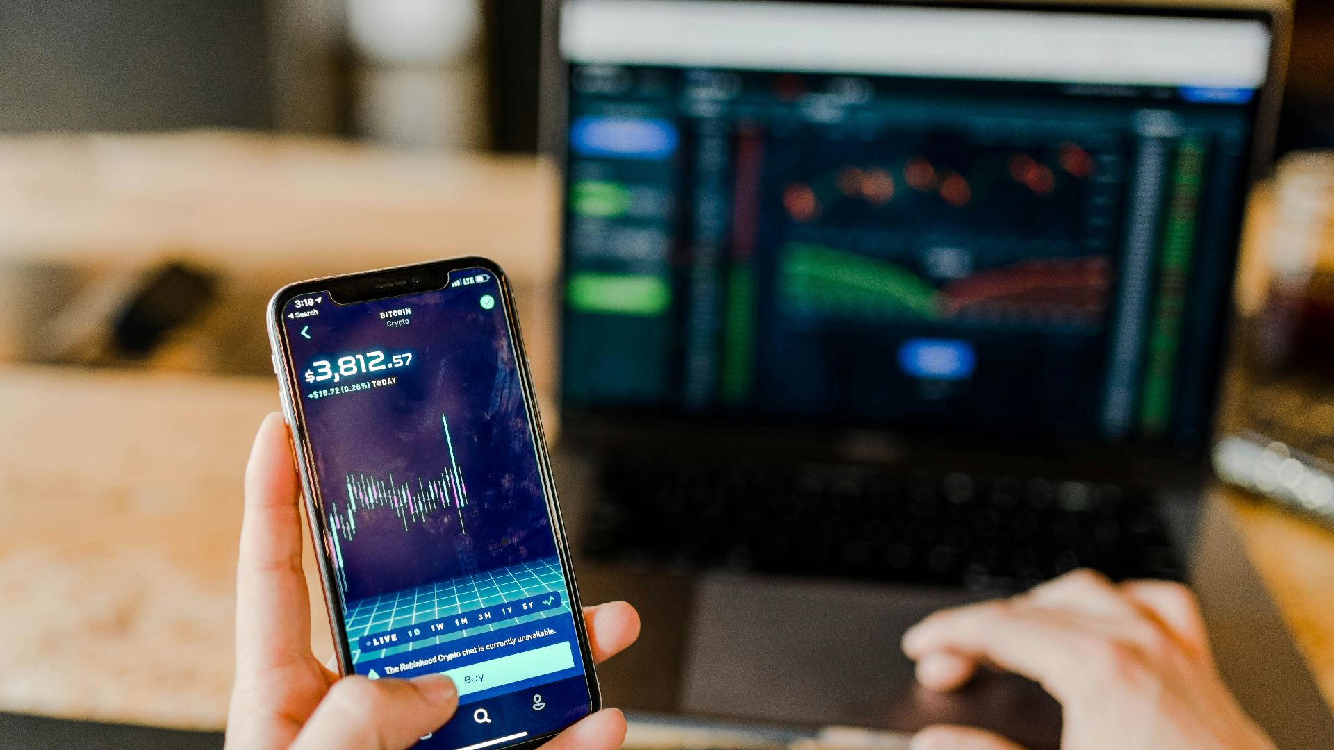 person using phone and laptop computer