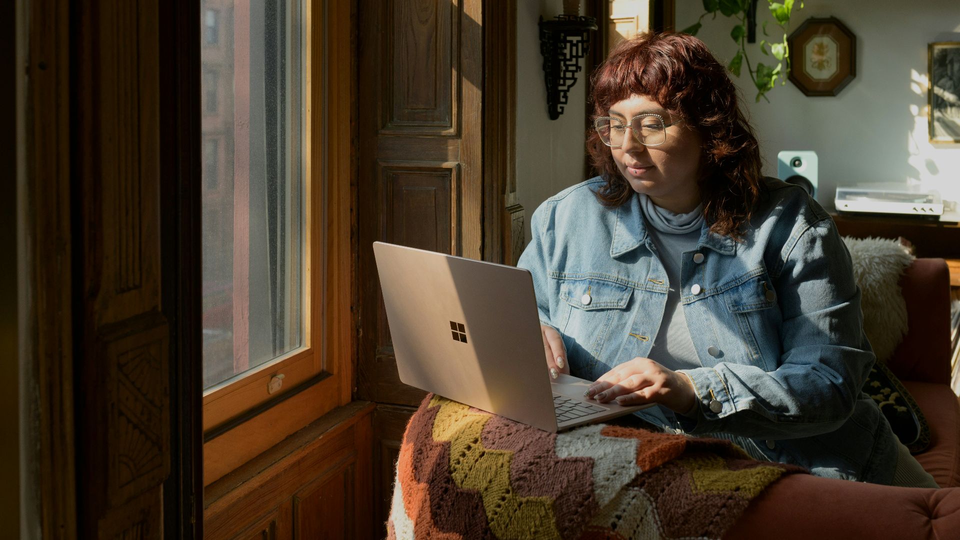 a woman sitting on a couch using a laptop computer