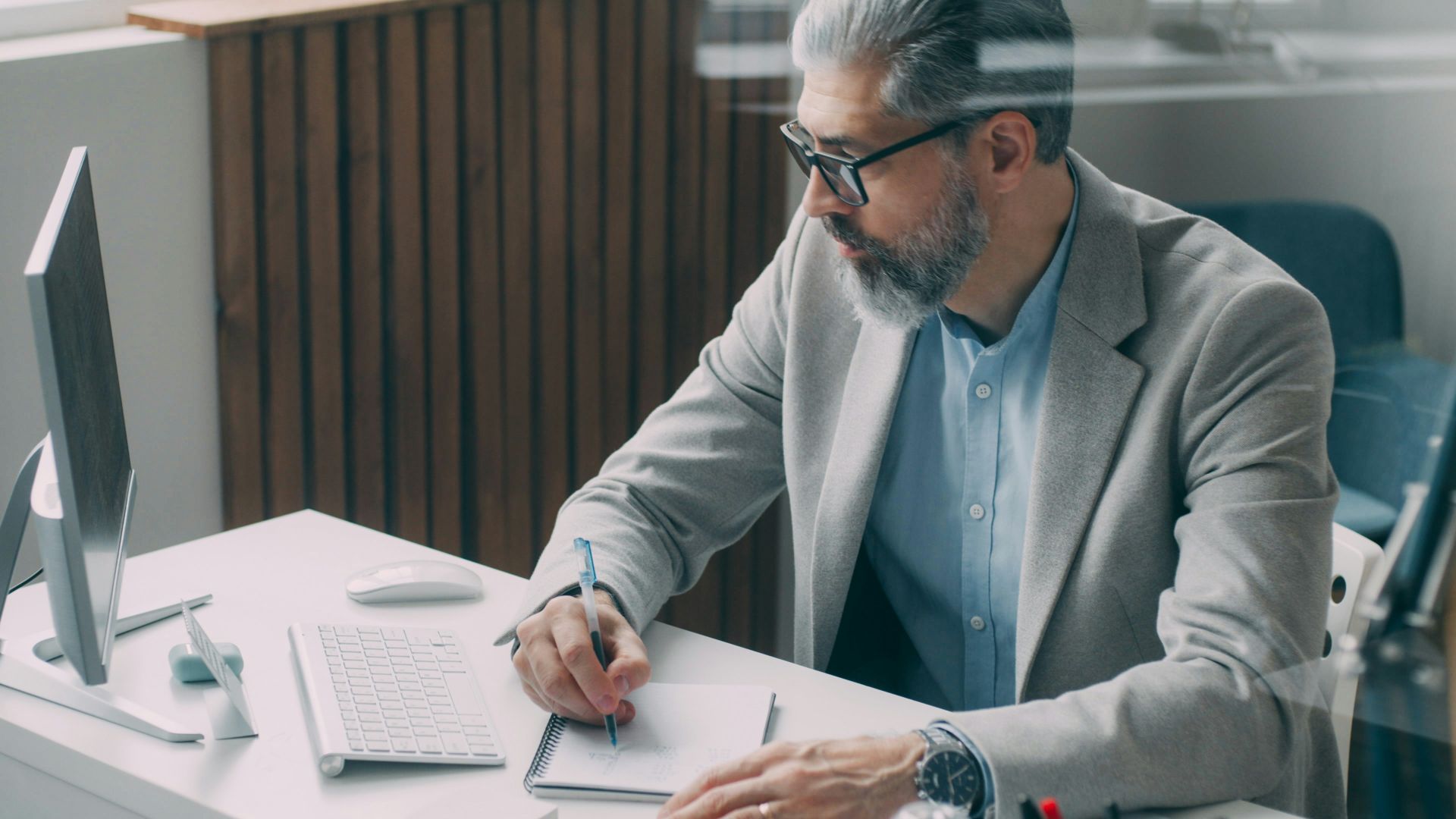 A man sitting at a desk writing on a piece of paper