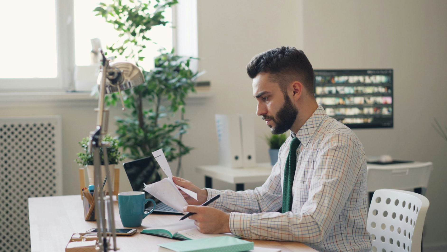 a man sitting at a desk with a laptop and papers