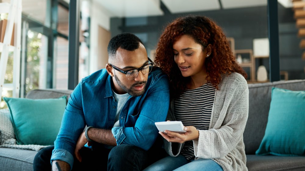 Calculator, financial checklist or couple writing with budget paperwork