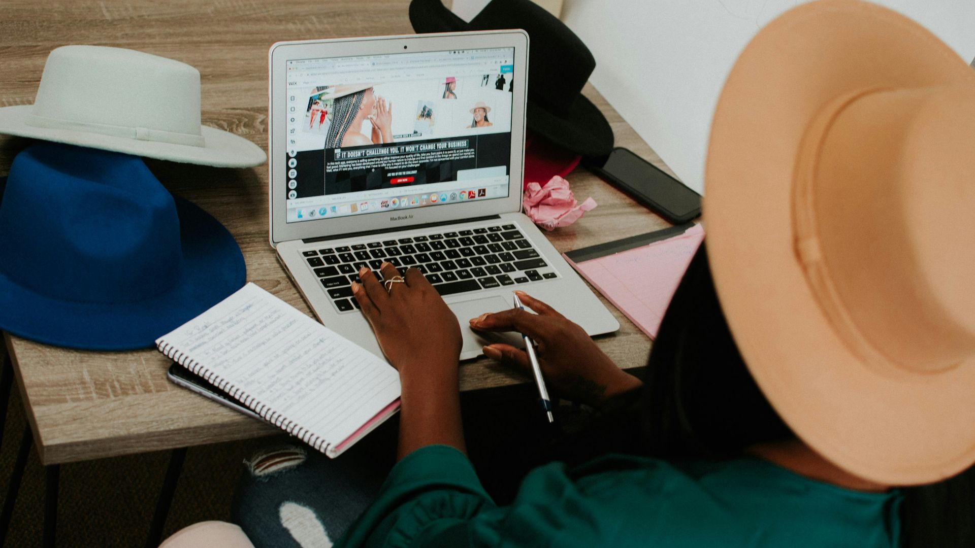 person using macbook air on brown wooden table