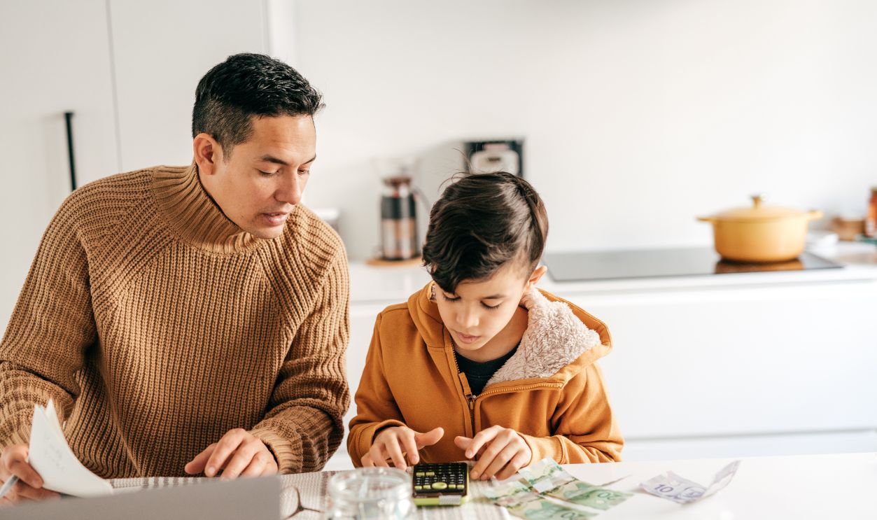 Family finances and math lessons during homeschooling time.Dad and son with cash sitting in the kitchen