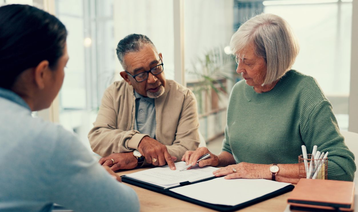 Talking, lawyer or old couple with will, contract or documents for life insurance papers or compliance. Plan, advisor or married elderly clients signing paperwork, legal form or title deed agreement