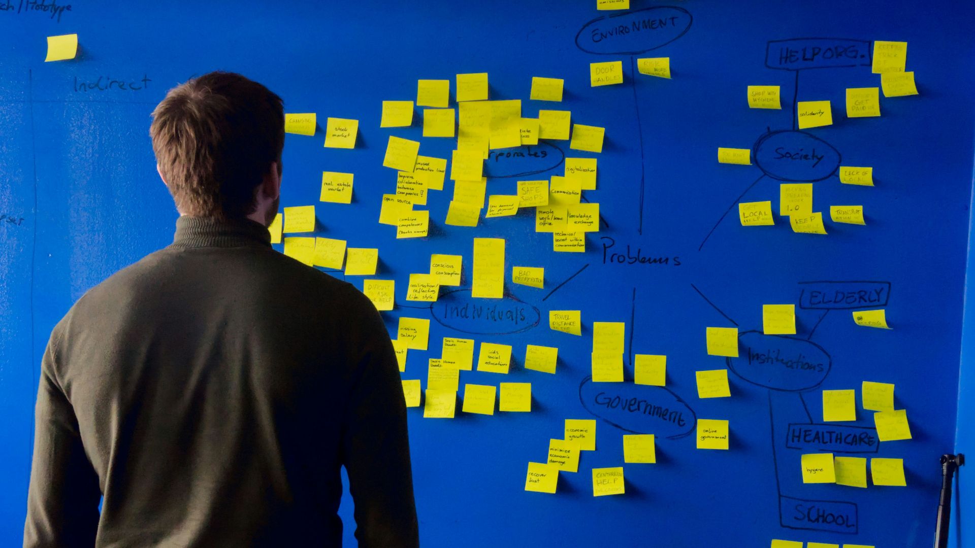 man in gray long sleeve shirt standing in front of blue and yellow puzzle mat