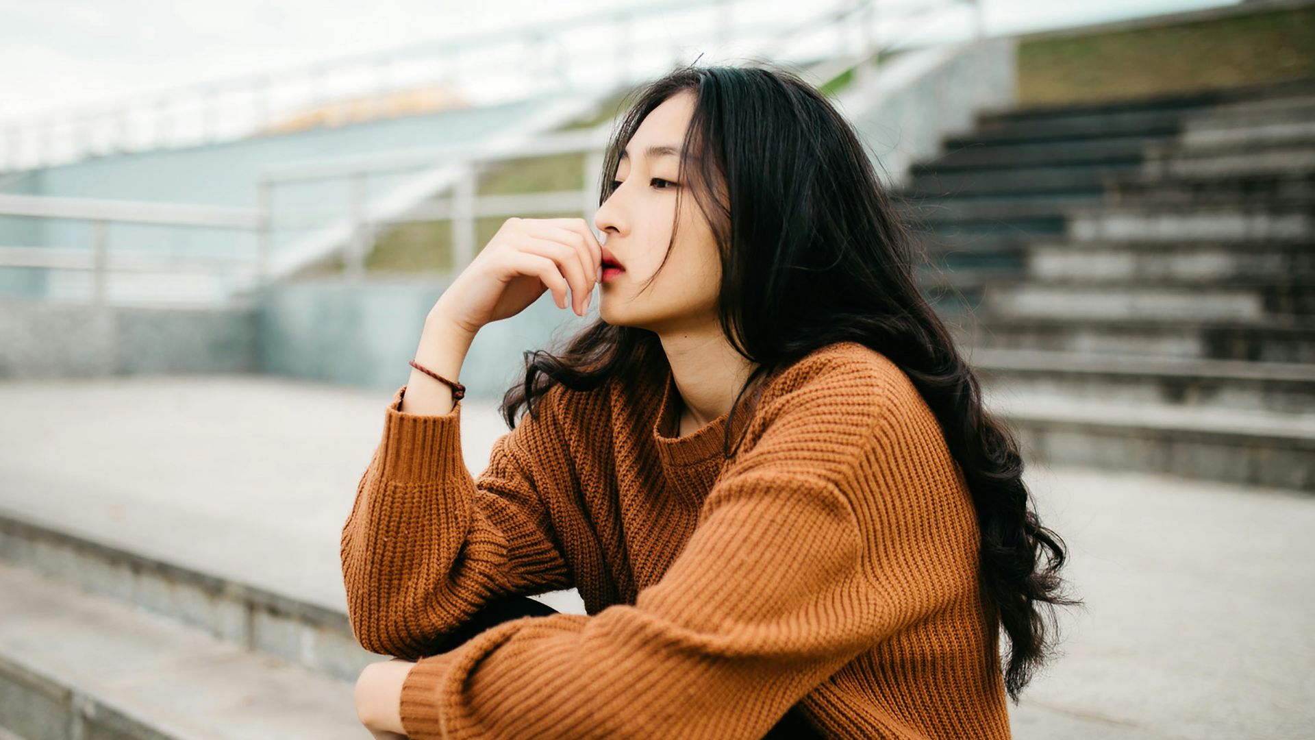 woman wearing brown sweater holding lips
