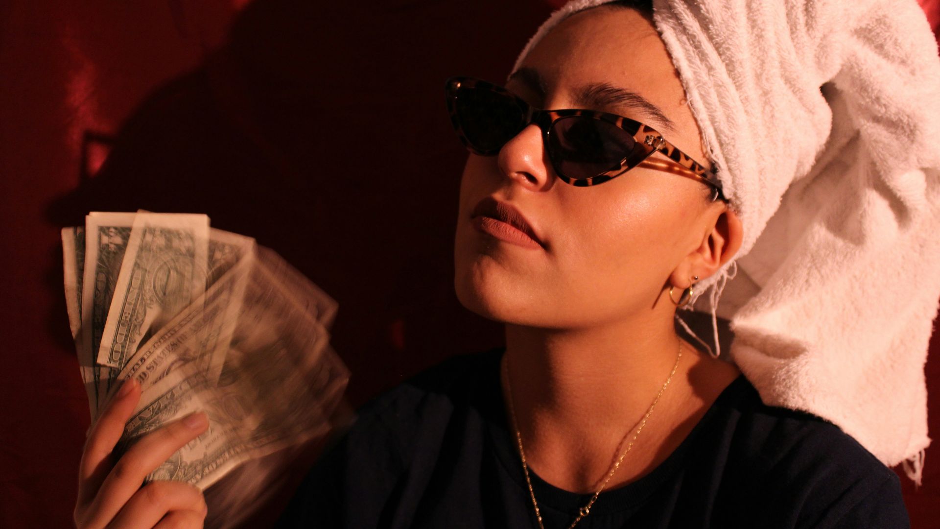 a woman with a towel on her head holding cash