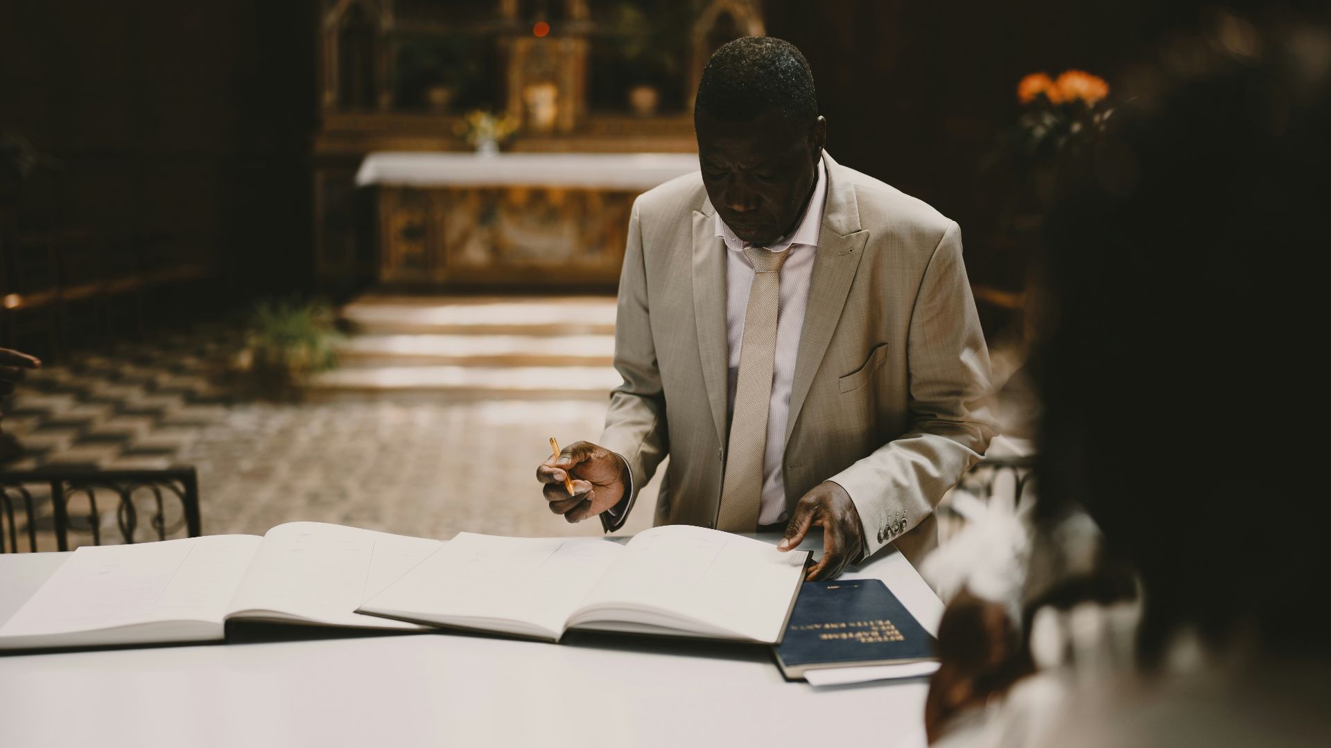 a man in a suit is writing on a book