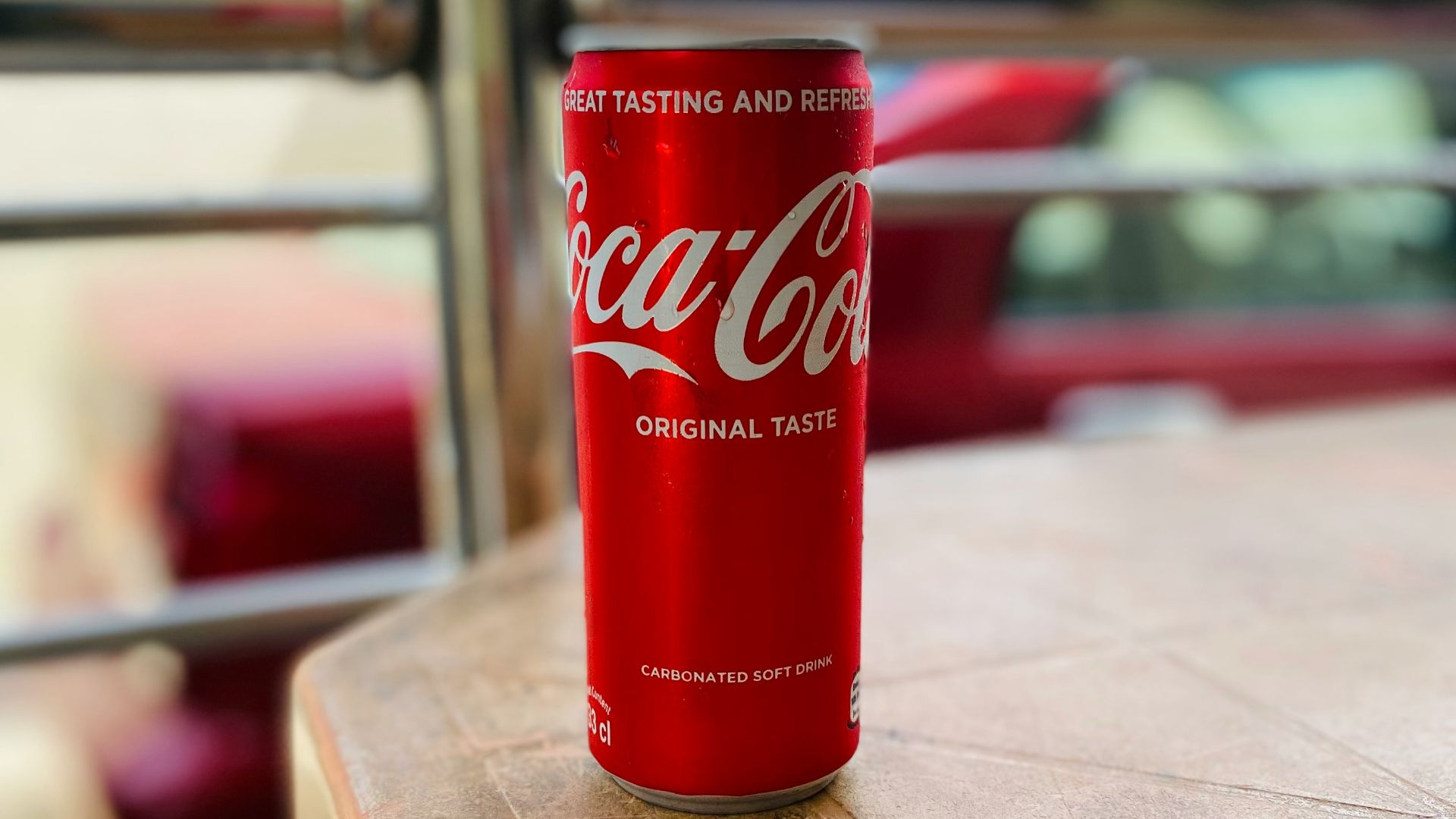 a red can of soda on a wooden table