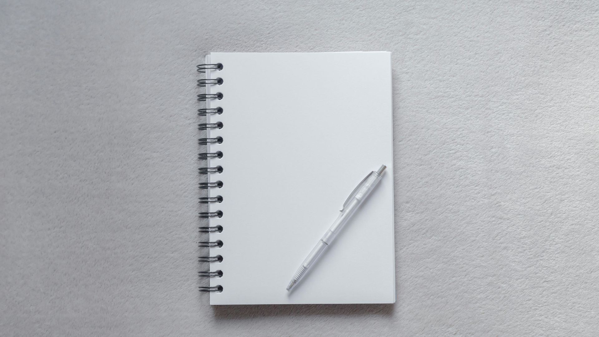 white notebook with pen on top