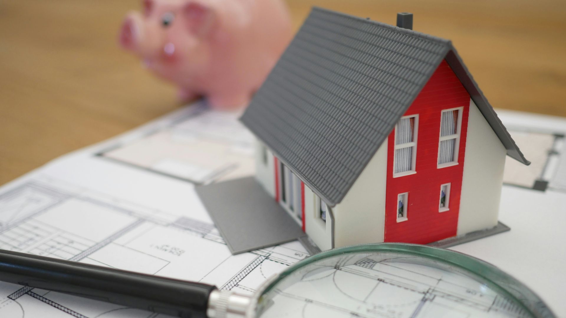 white and red wooden house beside grey framed magnifying glass