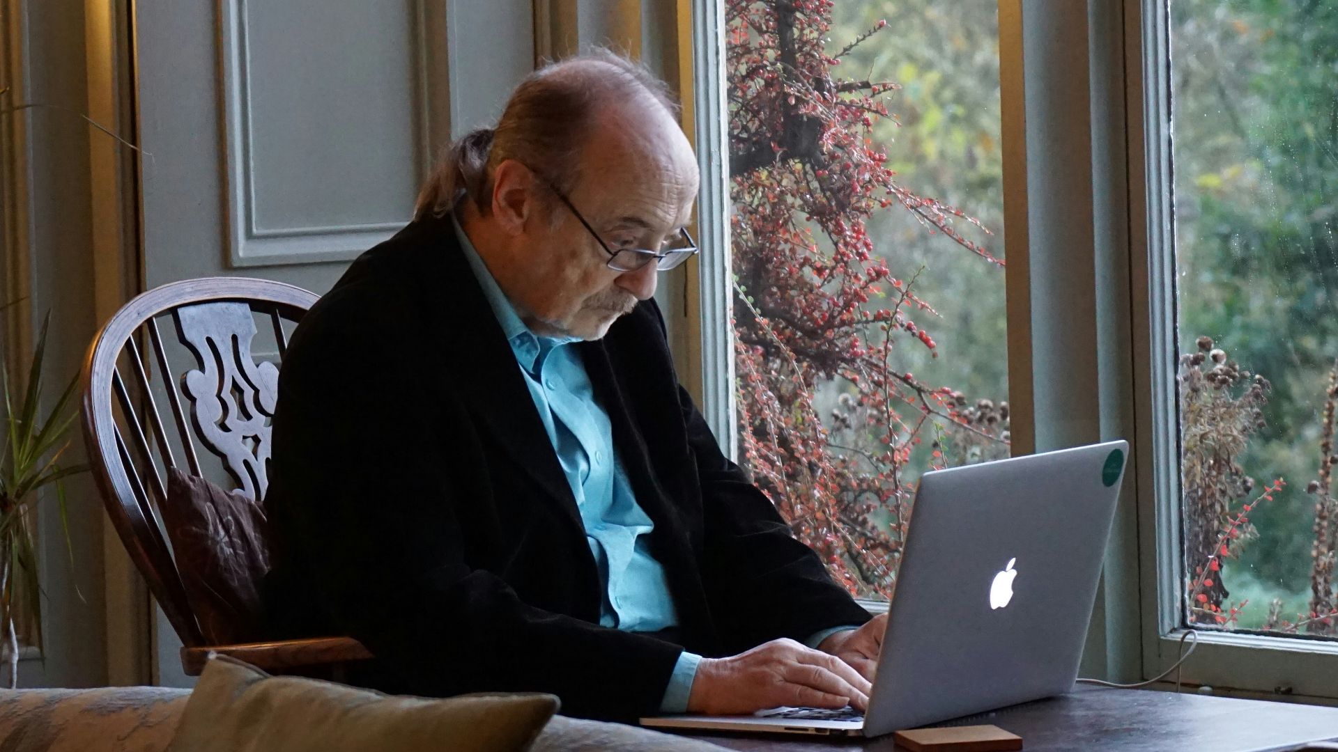 man in black suit jacket using macbook