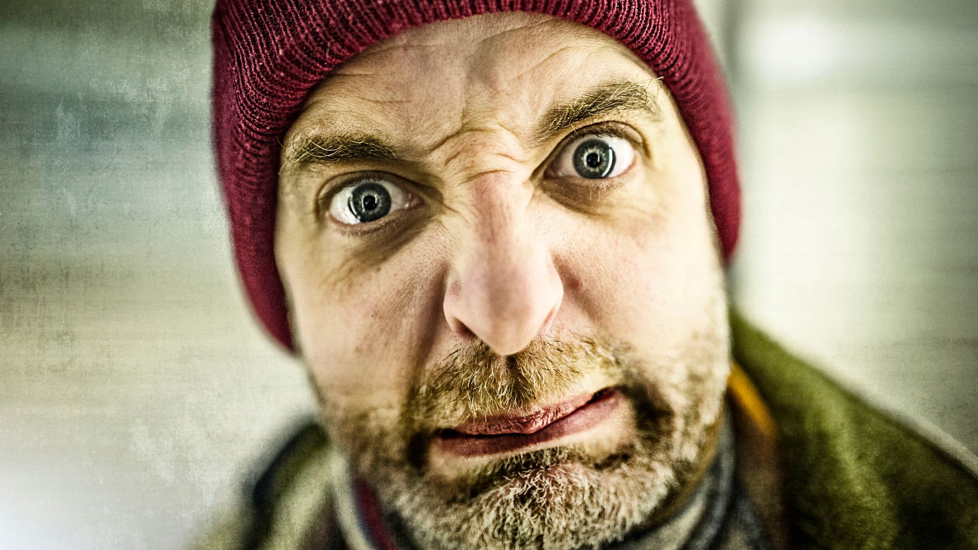 File:Man with beard and knit red cap frowns and has disgusted facial expression.jpg