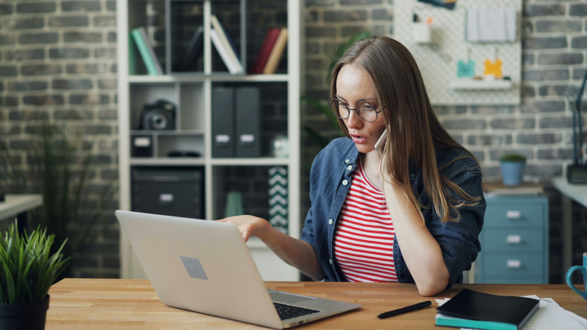 a woman sitting at a table using a laptop computer