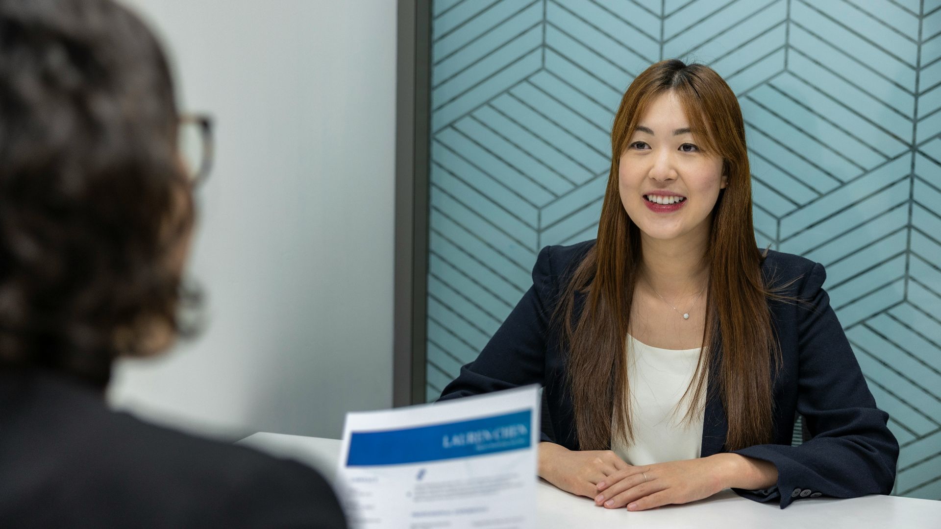 a woman sitting at a table with a piece of paper in front of her