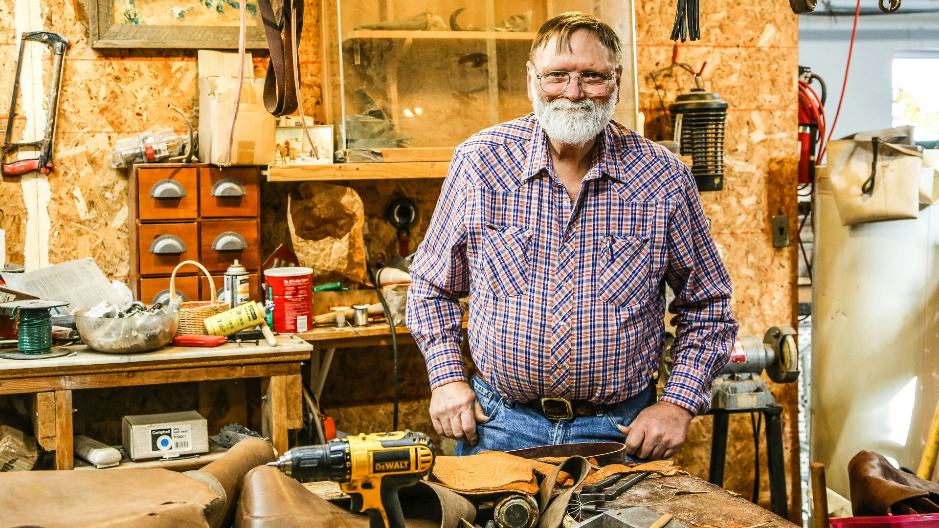 man in black and white checkered dress shirt holding black and yellow hand drill