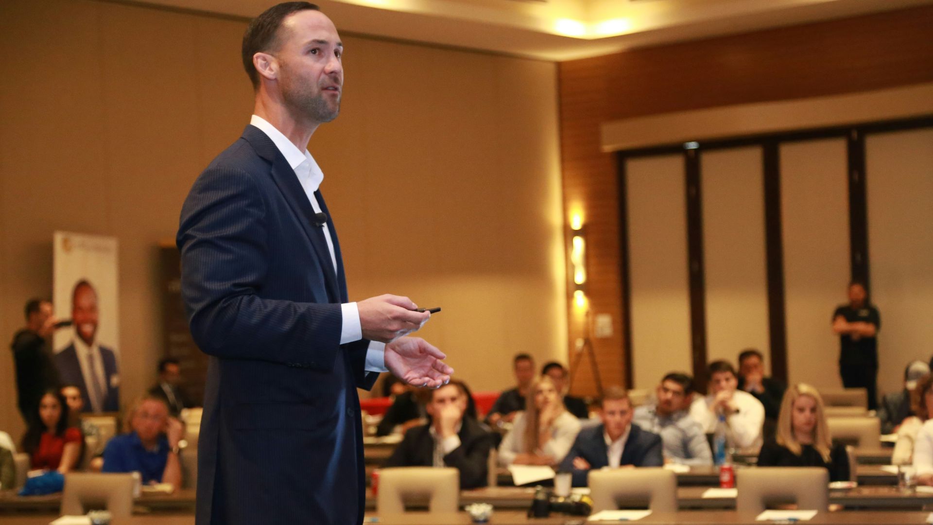 man in black suit standing on brown wooden floor