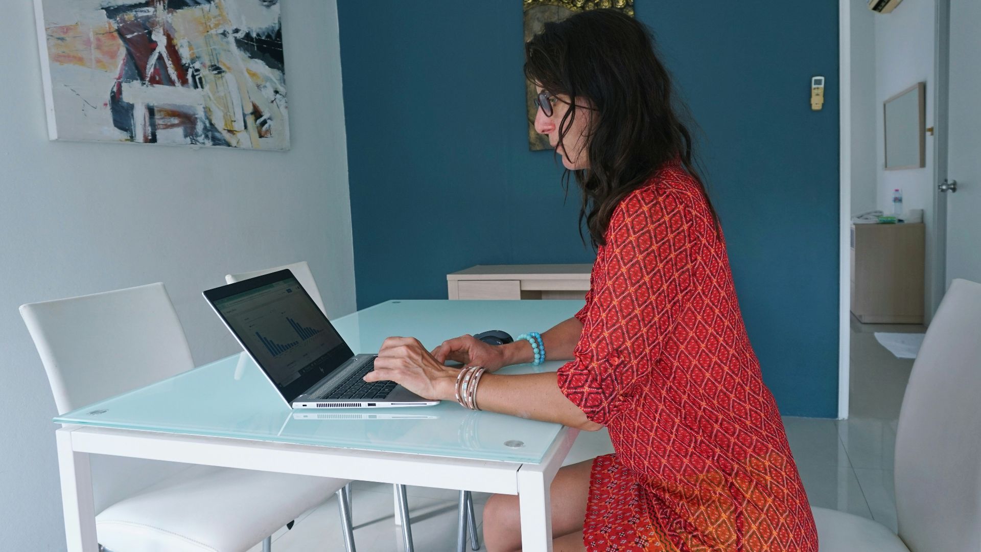 Woman works on laptop at a table.