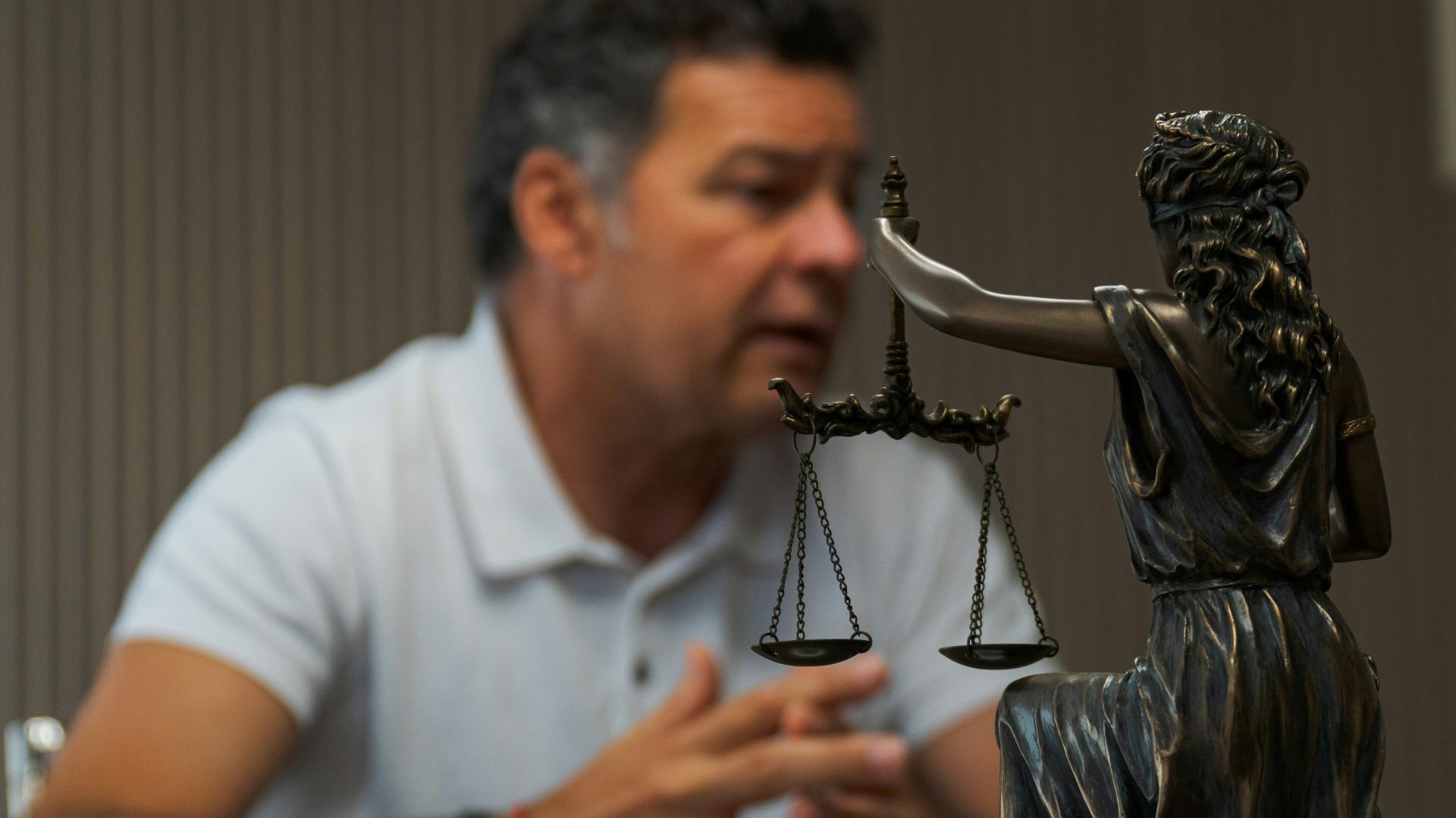 A man sitting at a table in front of a statue