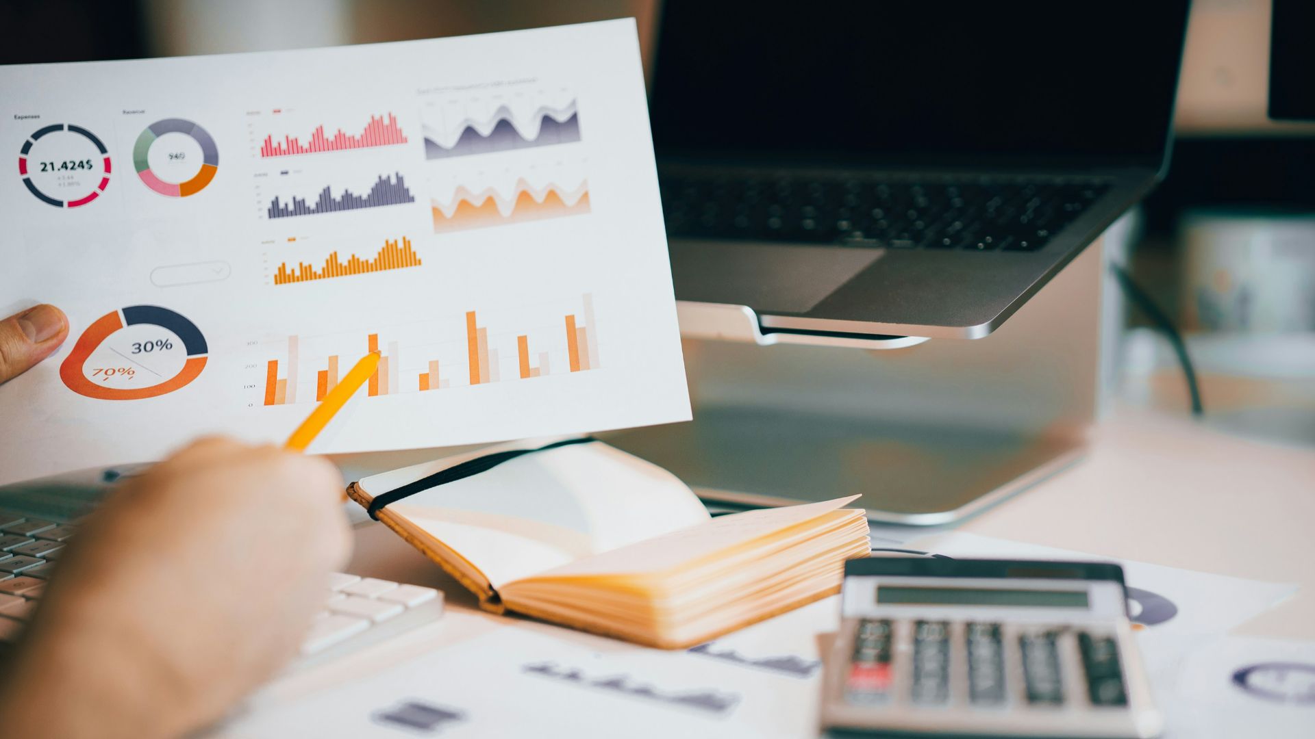 a person holding a piece of paper over a laptop