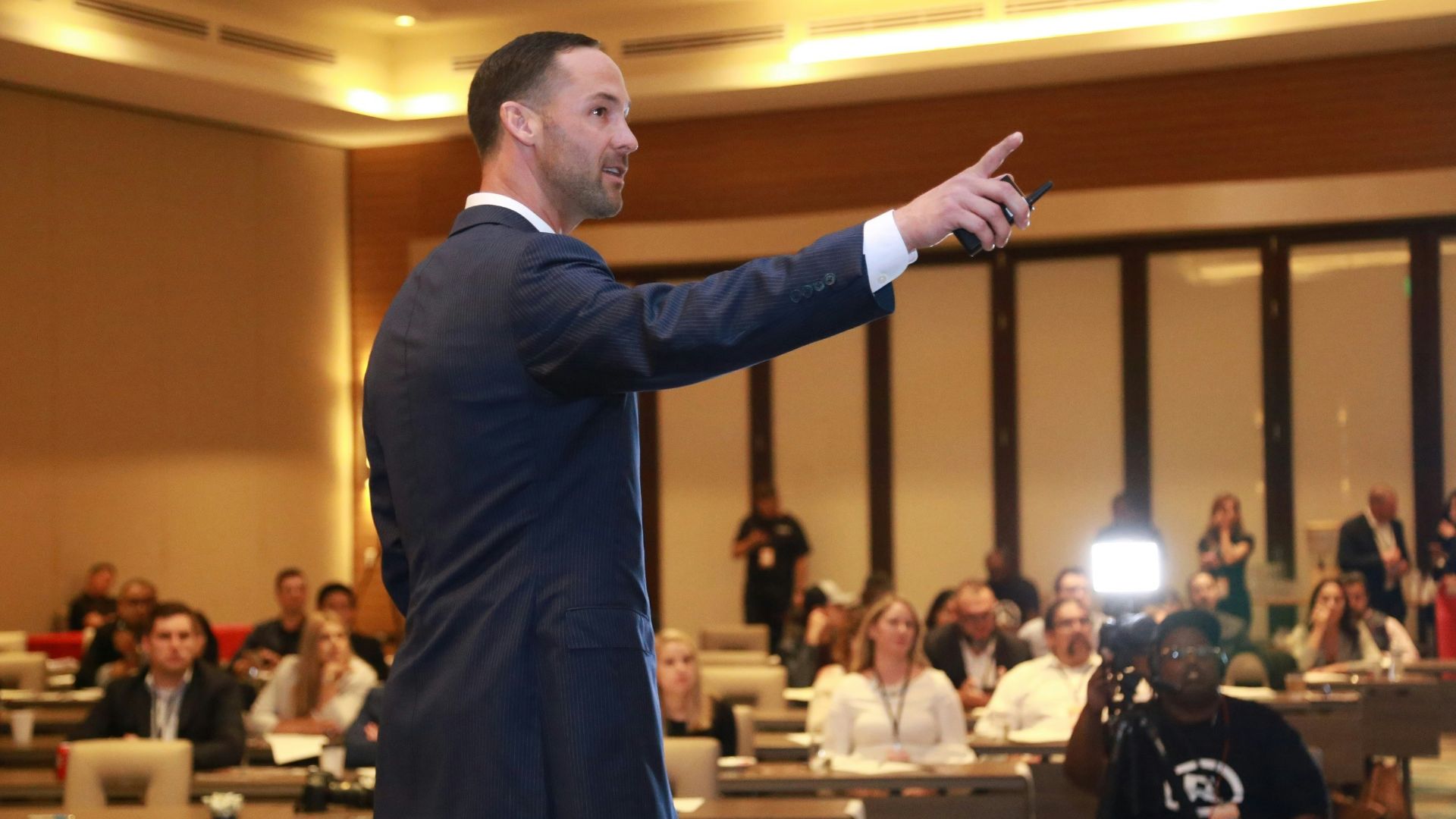 man in black suit standing on stage