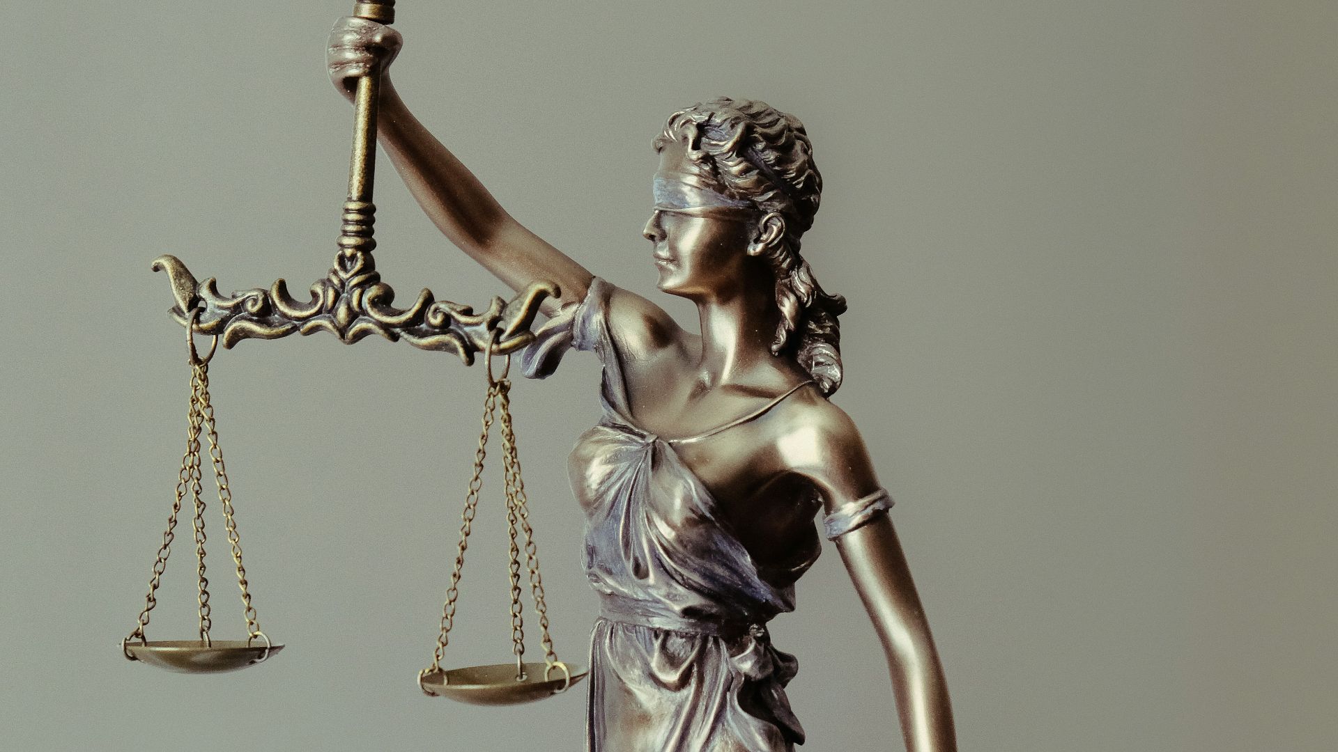 woman in gold dress holding sword figurine