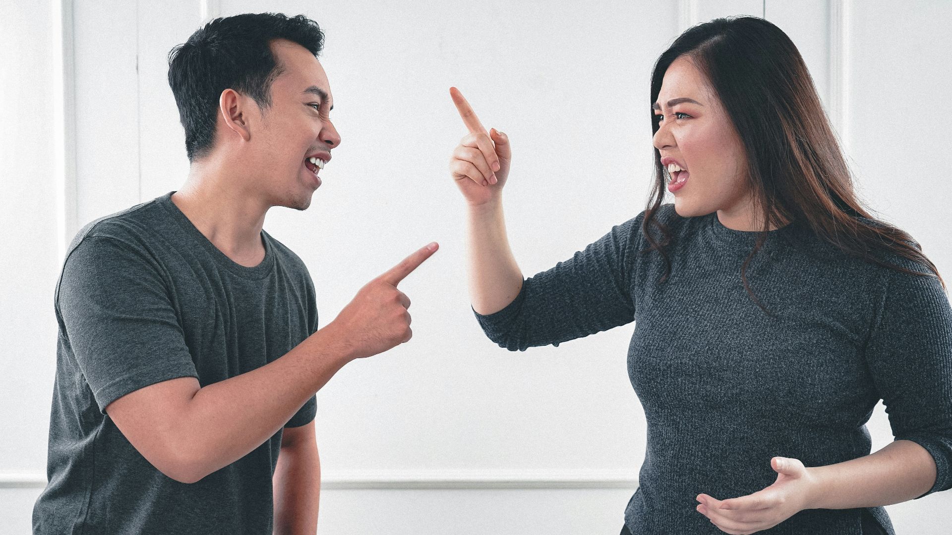 man in gray crew neck long sleeve shirt standing beside woman in black crew neck shirt