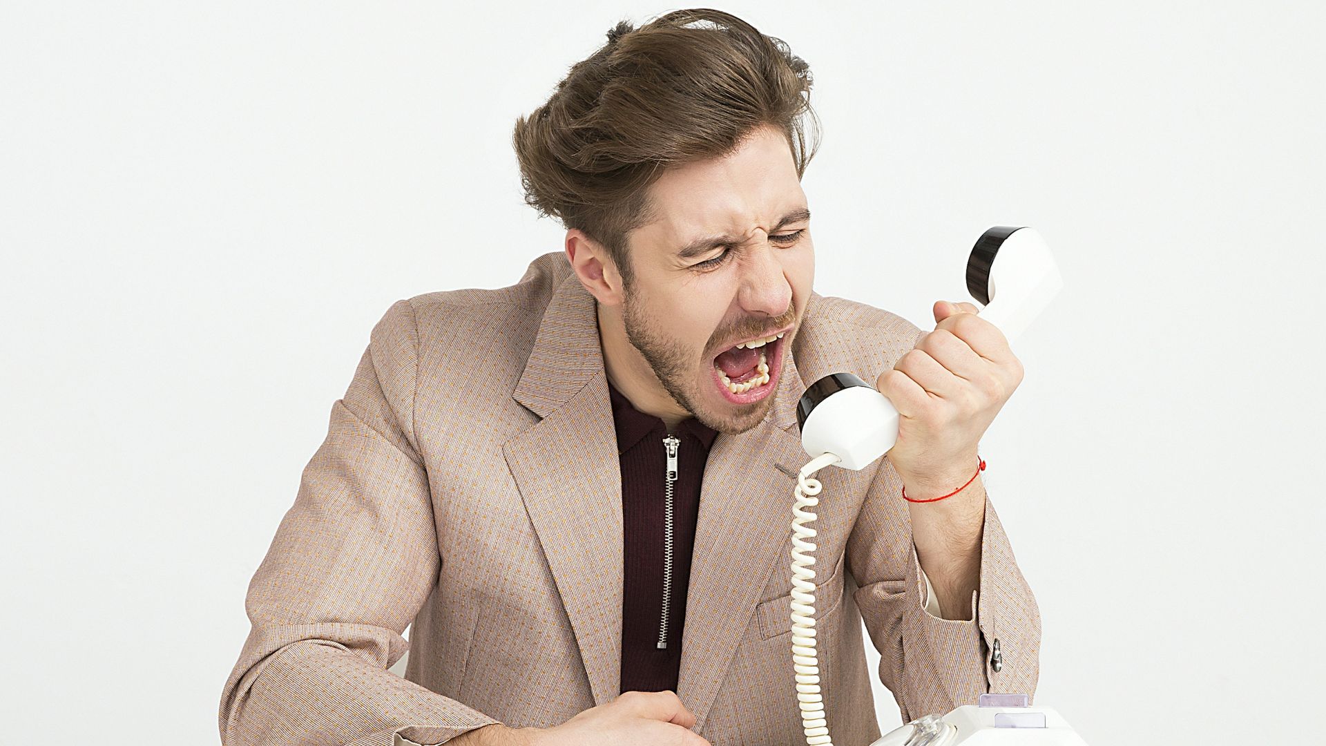 man holding telephone screaming