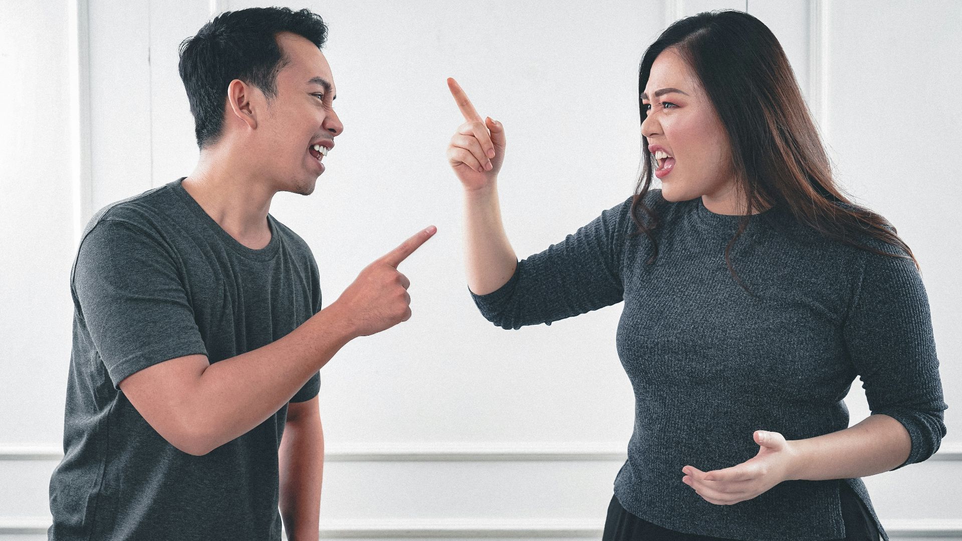 man in gray crew neck long sleeve shirt standing beside woman in black crew neck shirt