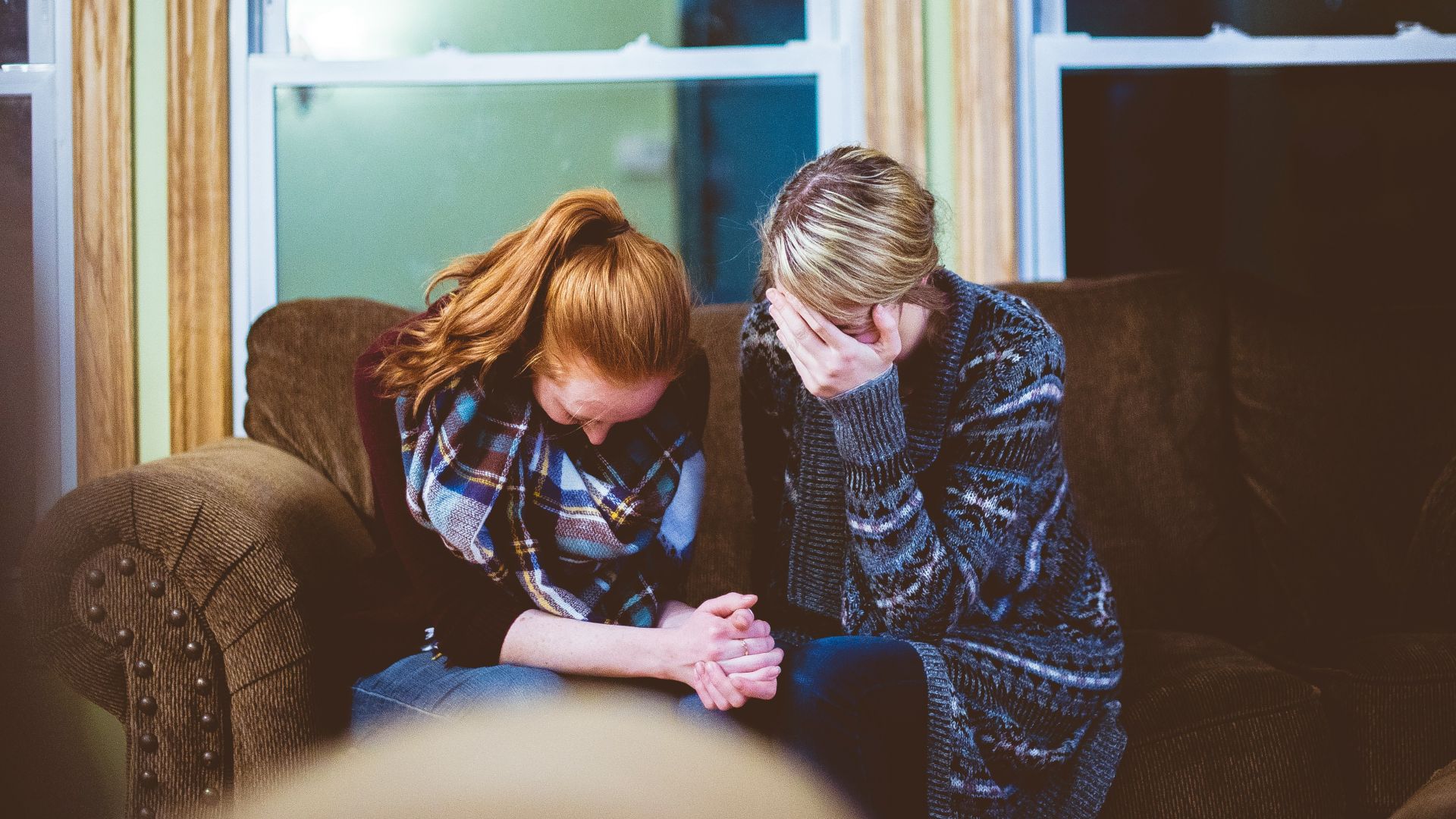 man and woman sitting on sofa in a room