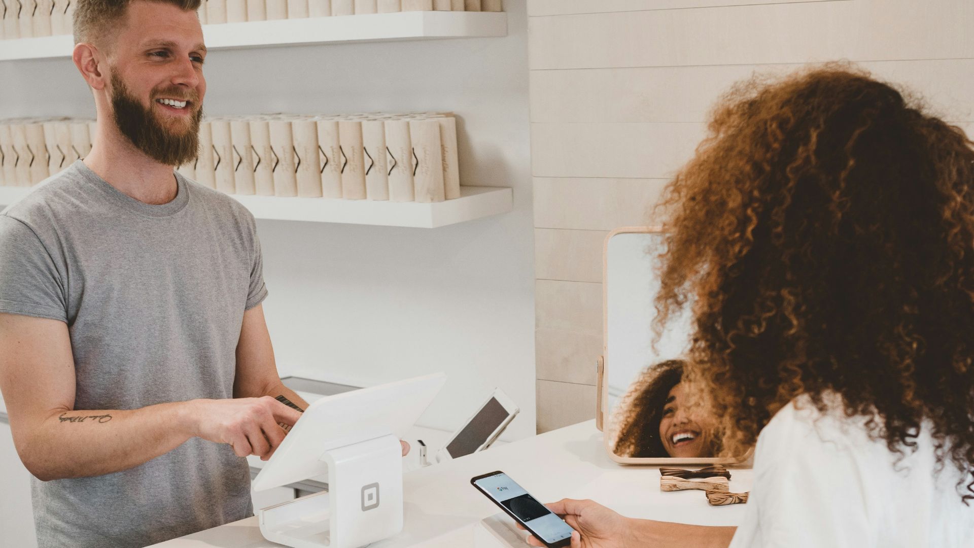 man in grey crew-neck t-shirt smiling to woman on counter