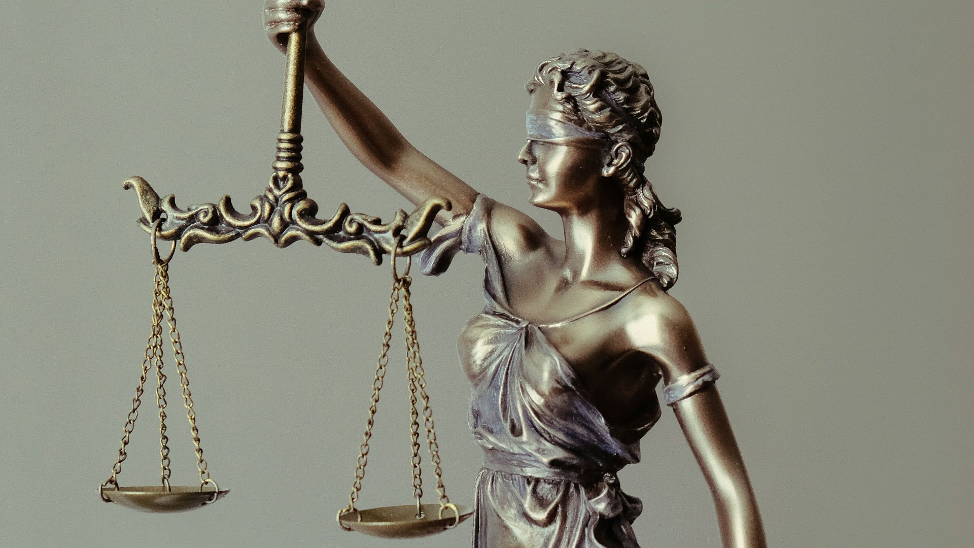 woman in gold dress holding sword figurine