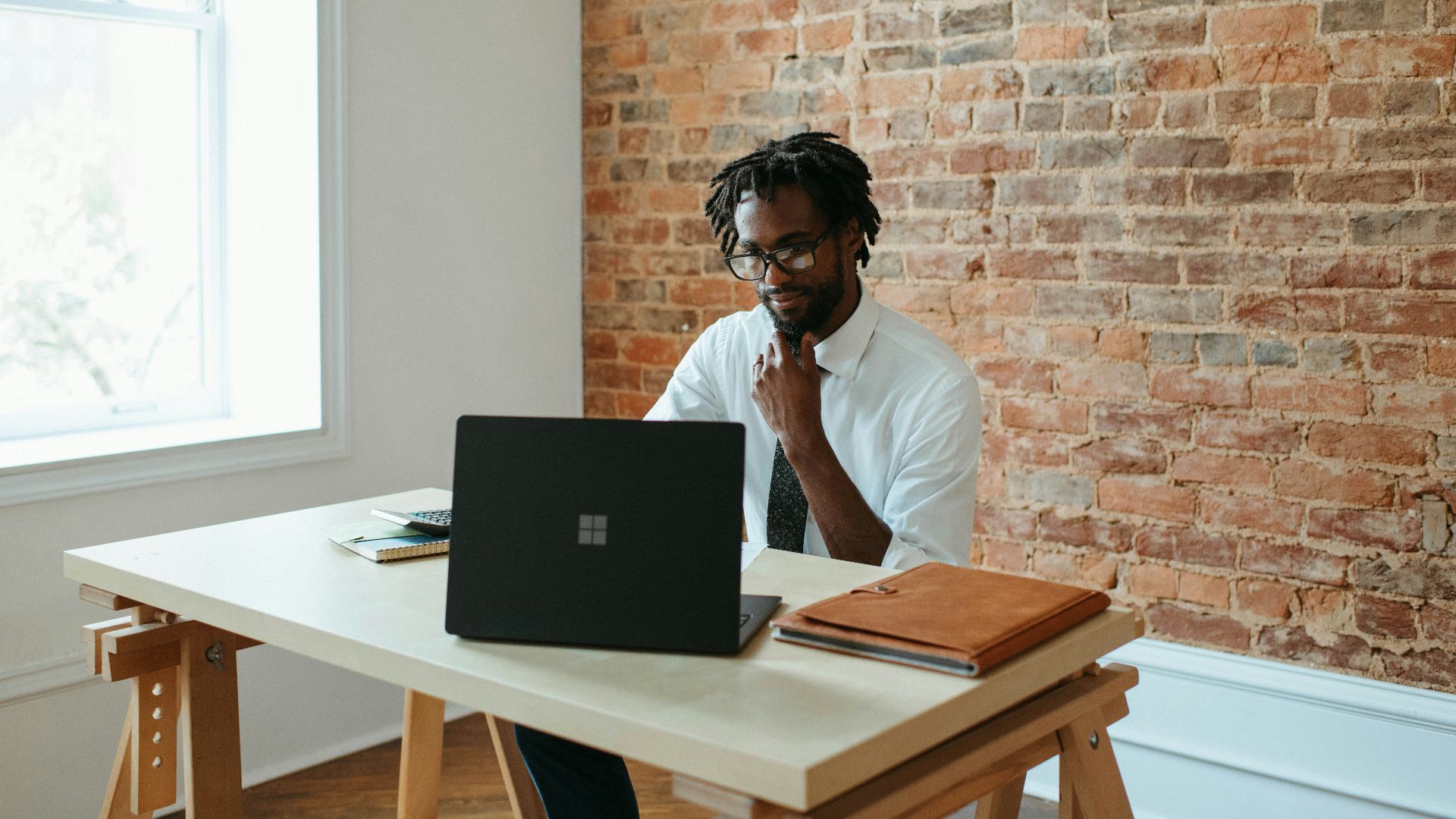 a man sitting at a table in front of a laptop