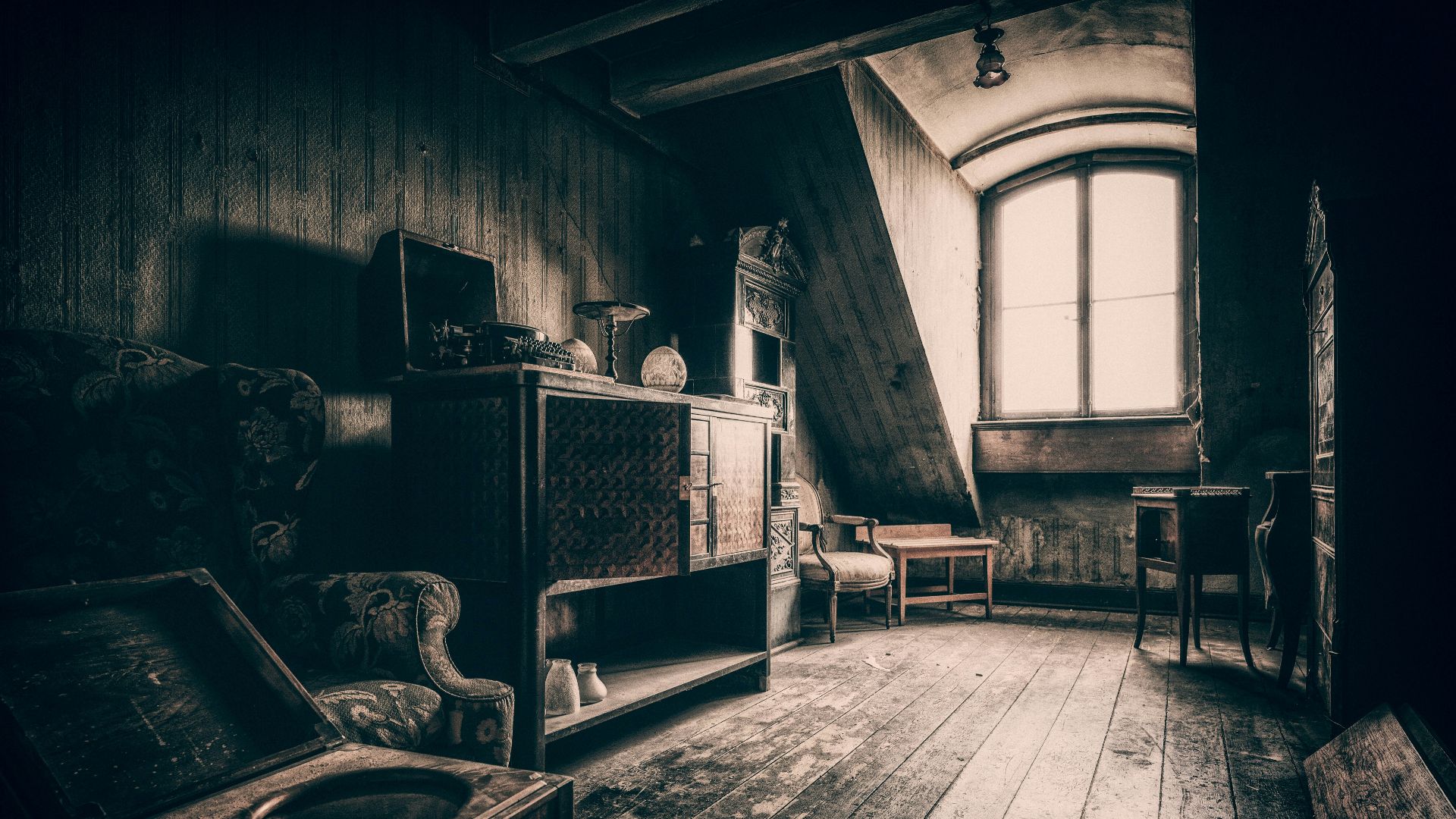 grayscale photo of wooden chair near window