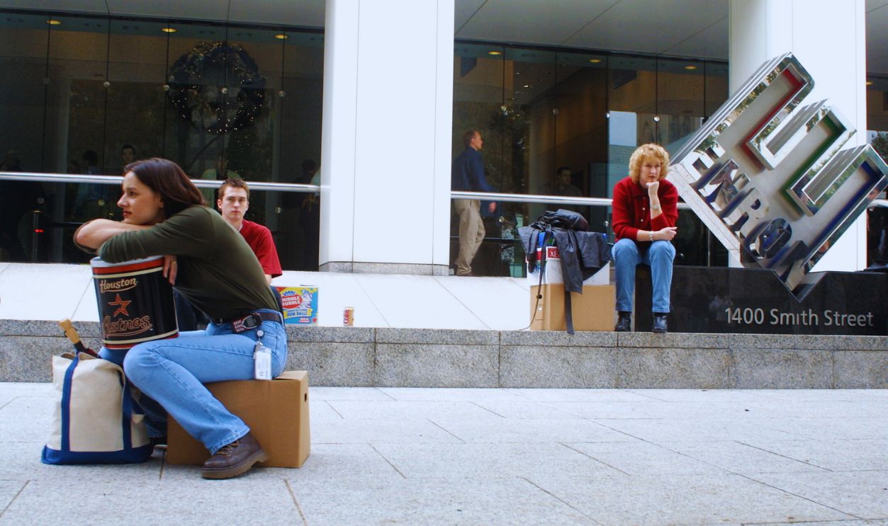 Gettyimages - 675237, Enron Files for Chapter 11, Lays Off Employees 398086 02: Meredith Stewart (L), who worked in Enron's networking/data processing department, sits on her personal belongings in front of the company's headquarters after being laid off December 3,2001 in Houston, Texas.