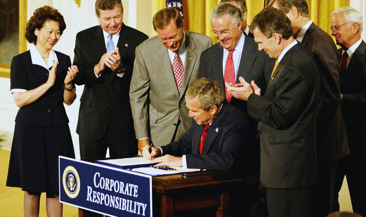 Gettyimages - 1645173564, US-BUSH-CORPORATE RESPONSIBLITY US President George W. Bush signs HR 3763 as members of the Congressional leadership and Cabinet members watch him sign the