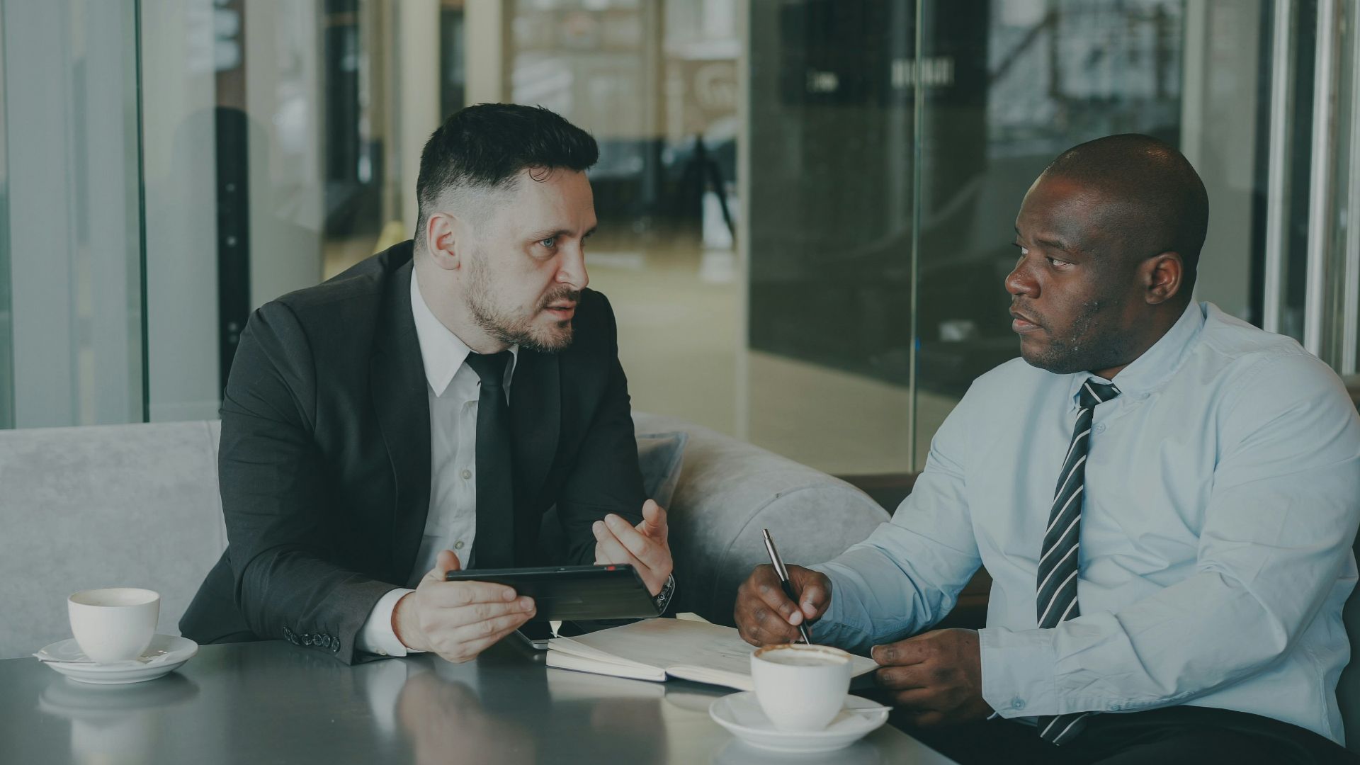 Two businessmen discussing work over coffee.