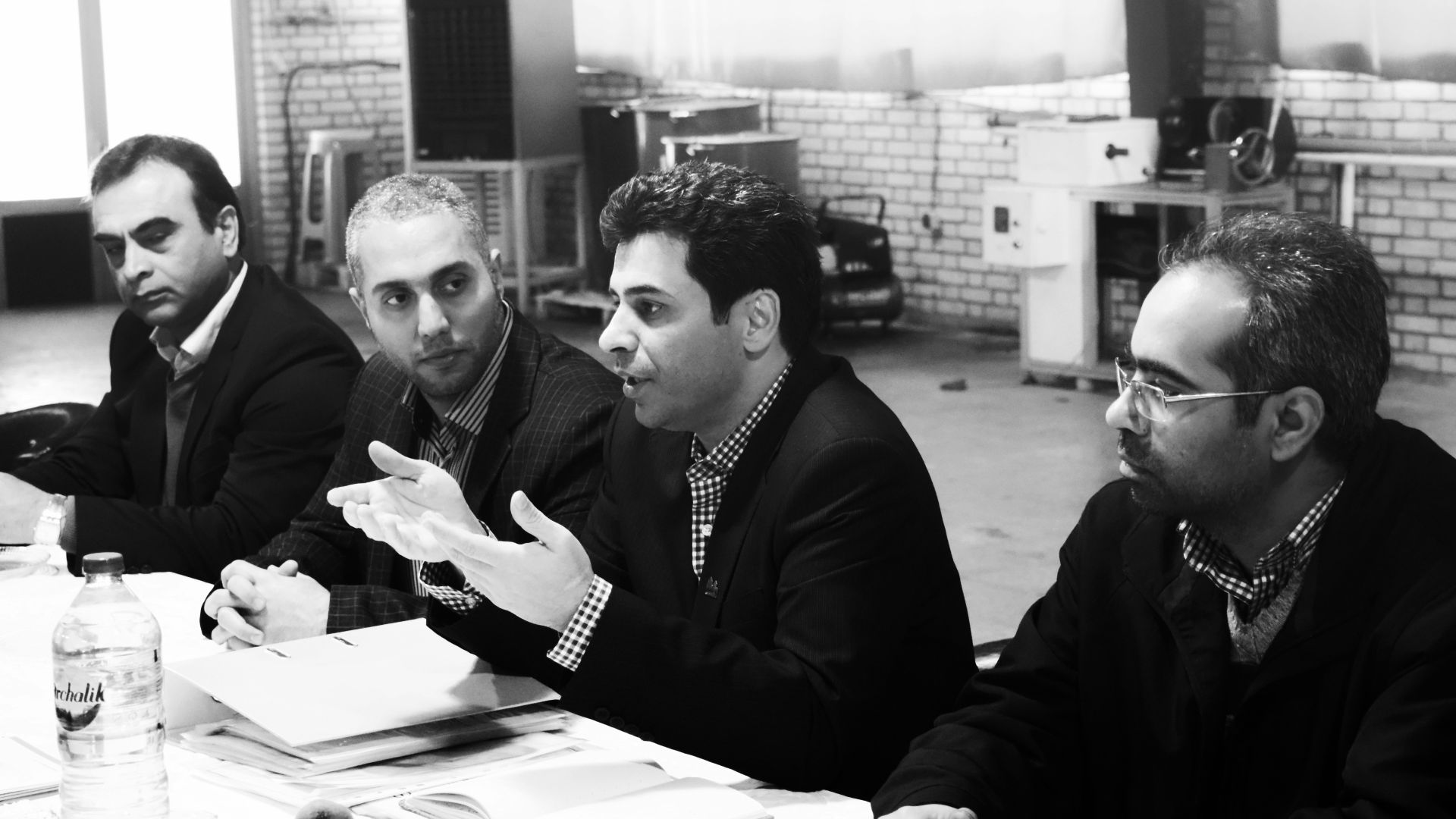 four men sitting at the table grayscale photo