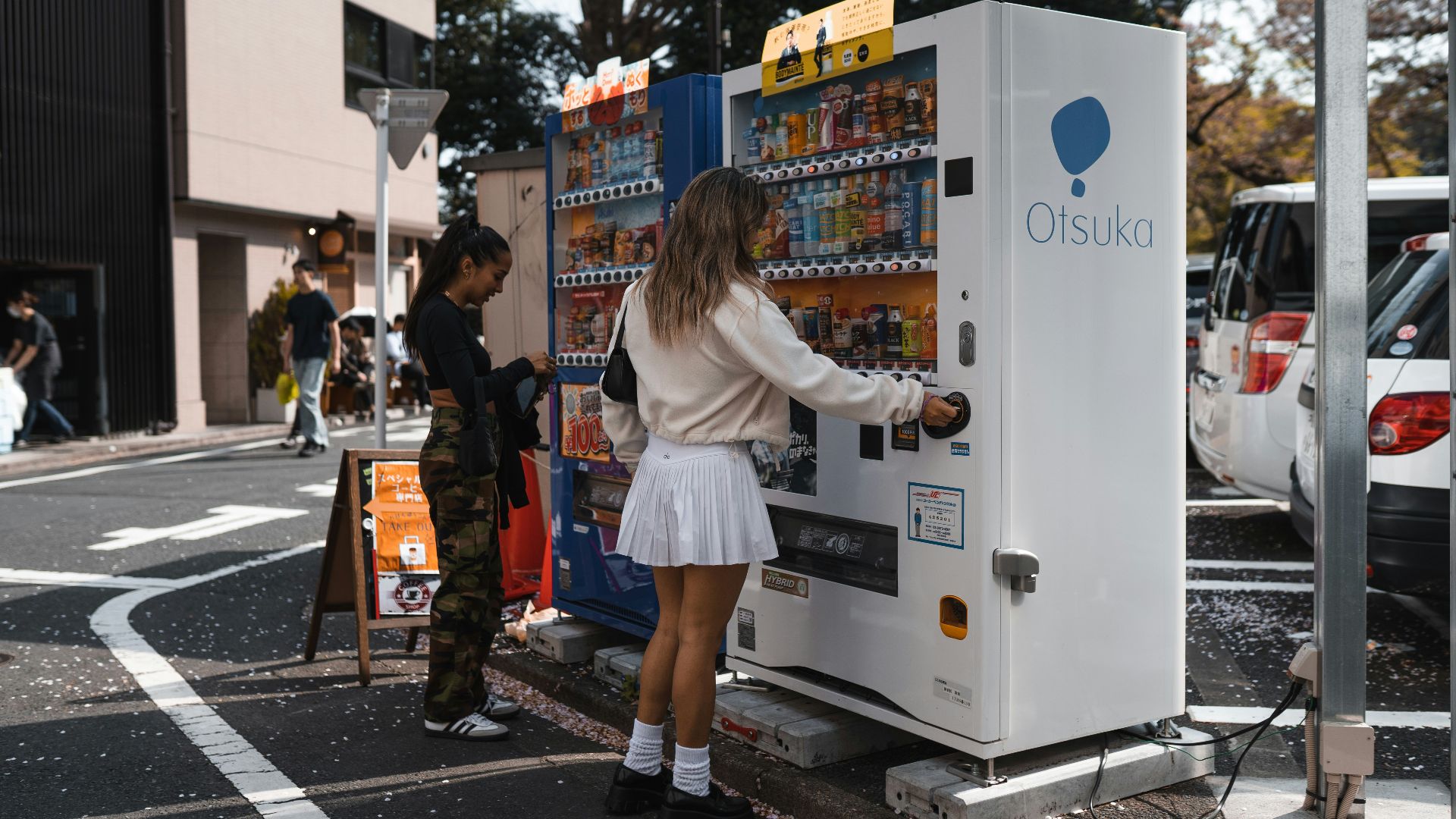 a woman standing next to a vending machine