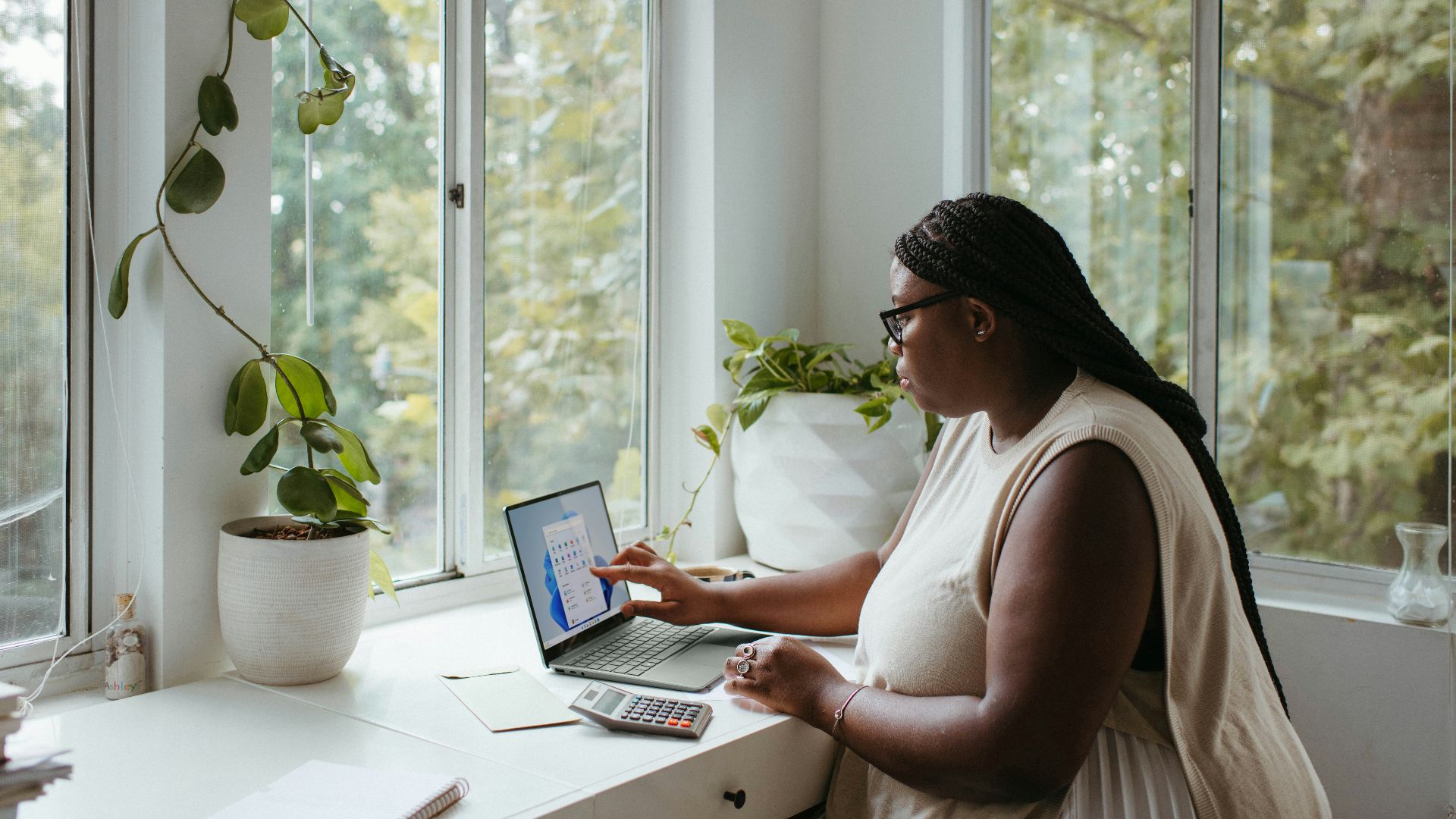 a woman sitting at a table with a laptop