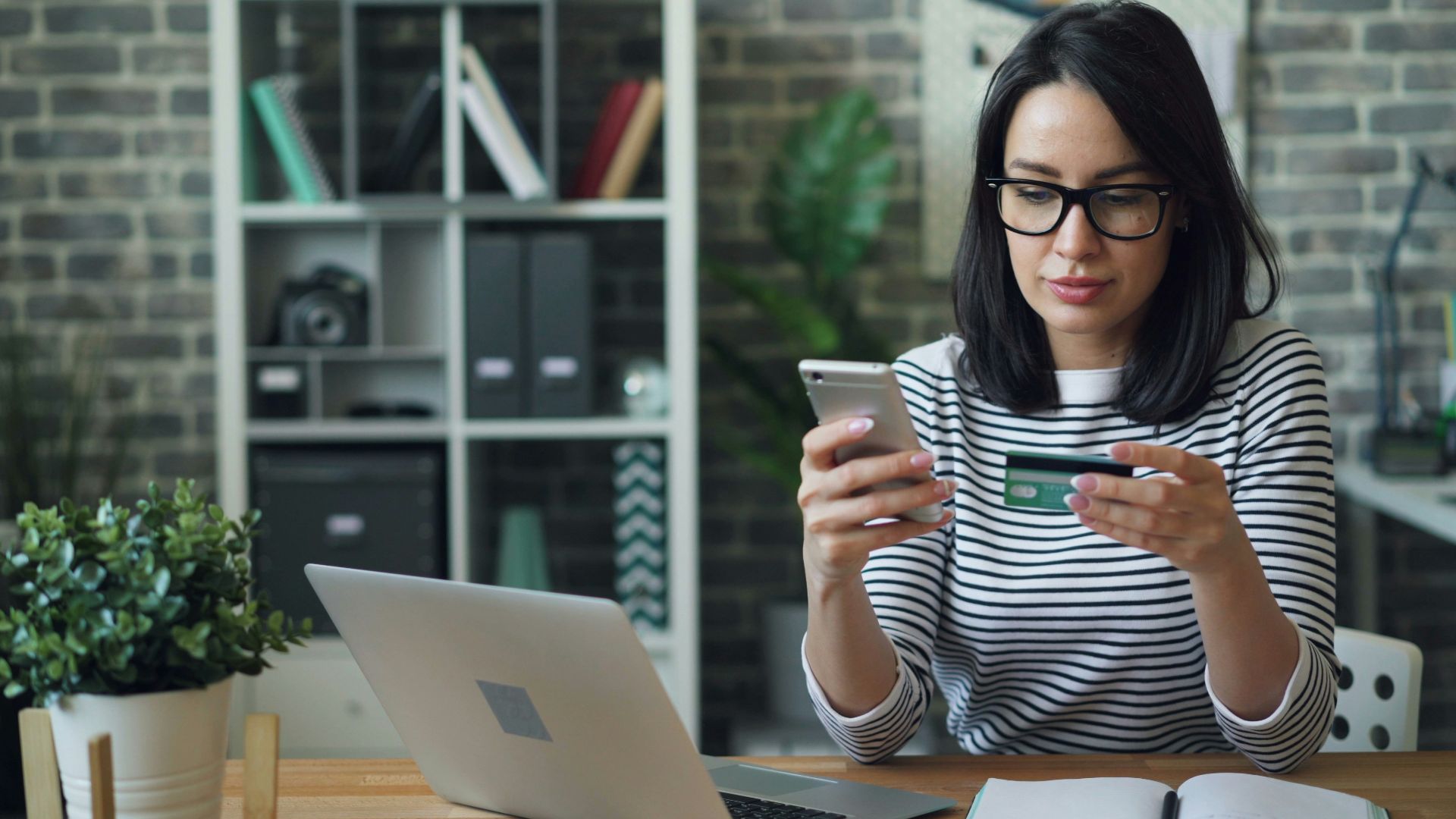 a woman sitting at a table looking at her cell phone