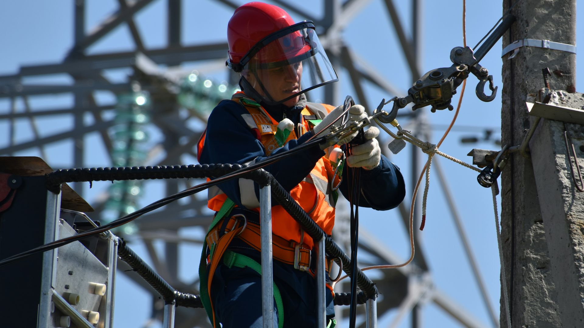 shallow focus photo of man fixing steel cable