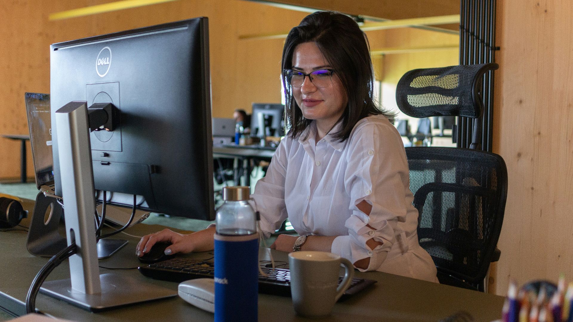 a woman sitting at a desk in front of a computer