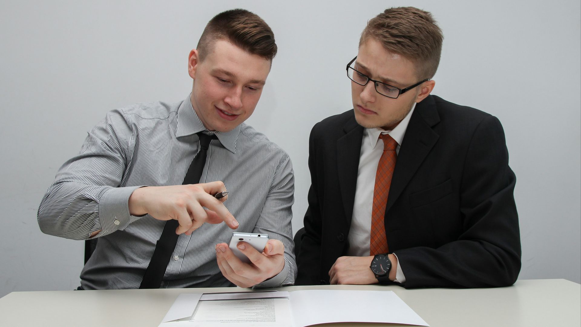 two man watching smartphone